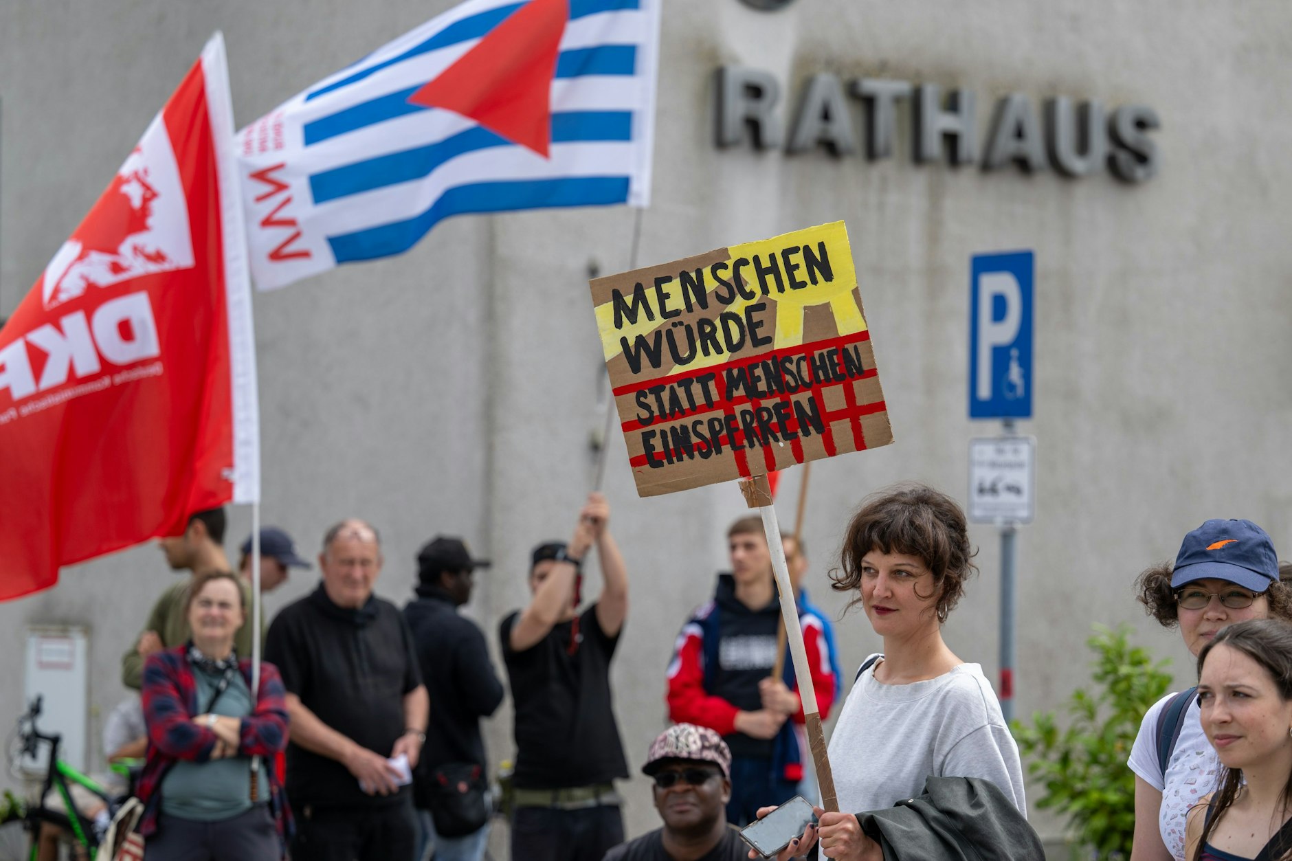 Teilnehmer einer Demonstration gegen das geplante Abschiebezentrum am Flughafen BER vor dem Schönefelder Rathaus.