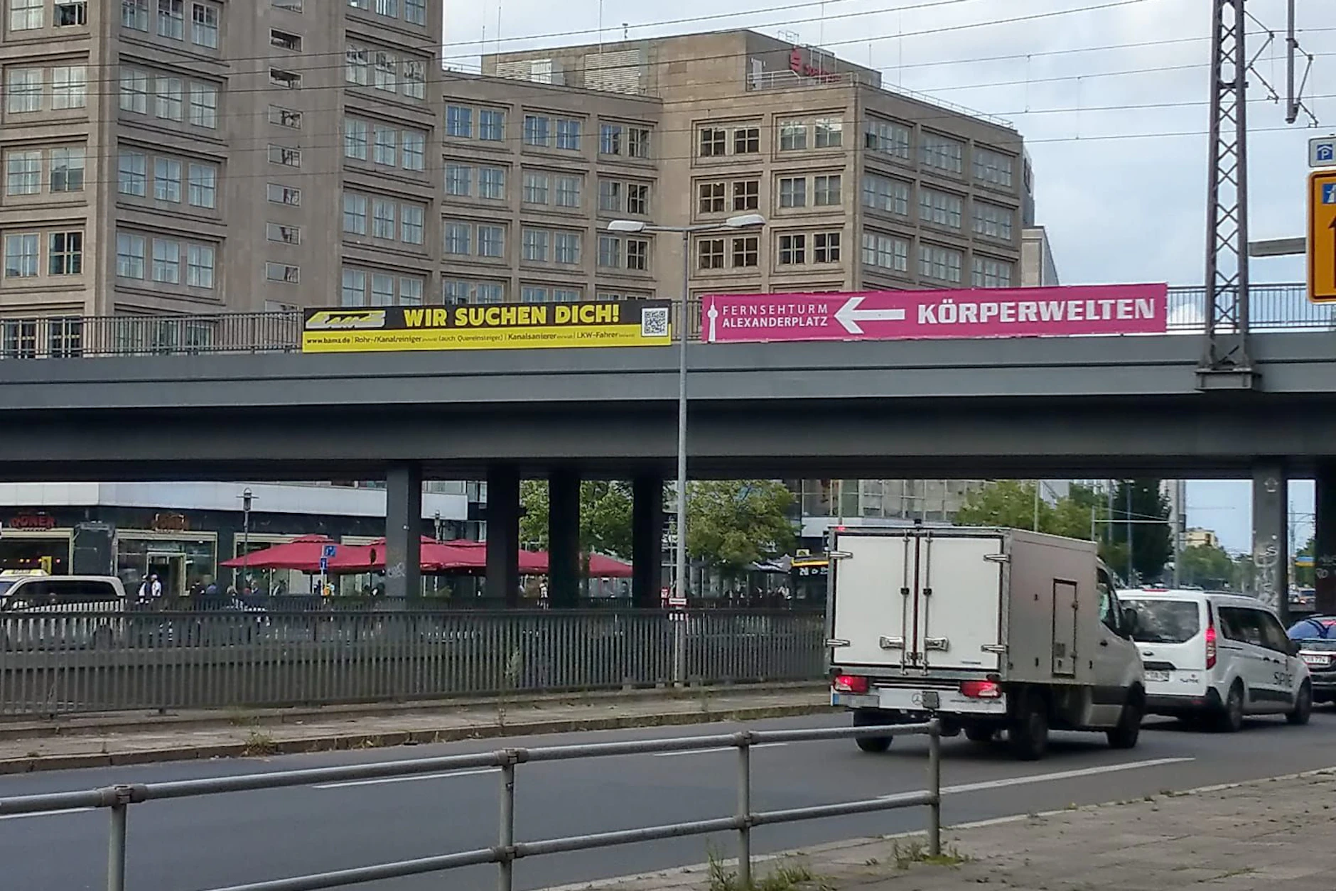 Diese Werbungen beim Alexanderplatz könnten lustiger aufeinander abgestimmt nicht sein.