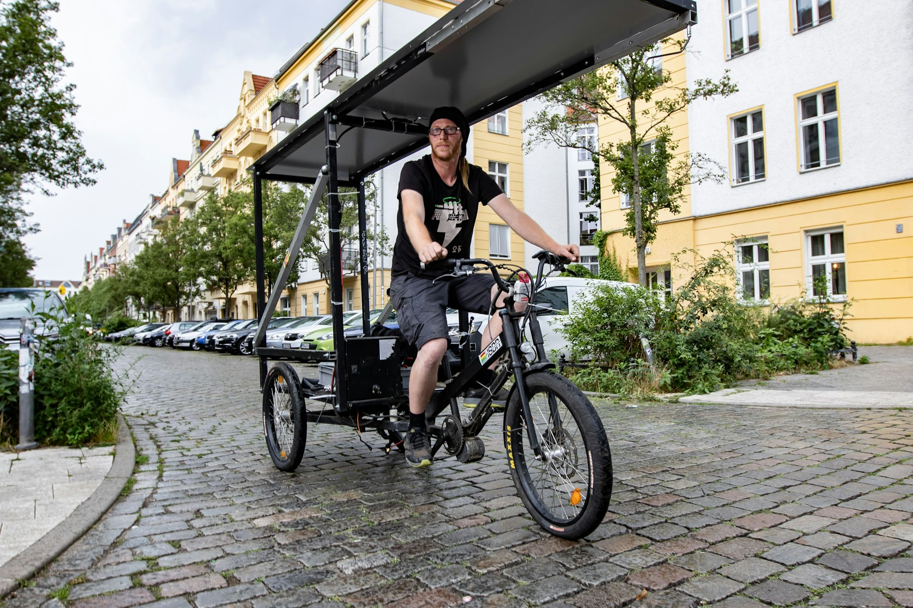 Sebastian Dorendorf posiert für ein Bild mit dem von ihm gebastelten Lastenrad in Friedrichshain.