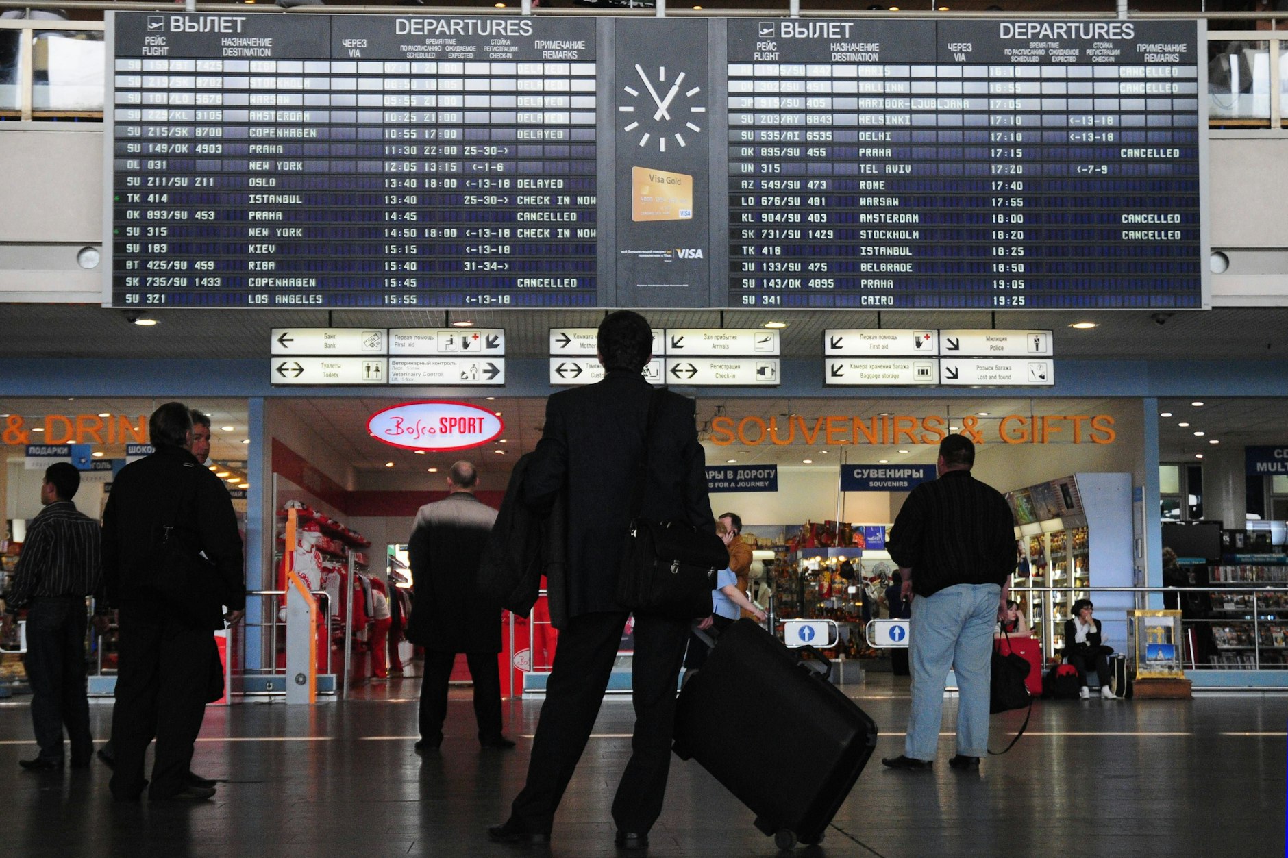 Passagiere blicken auf eine Abflugtafel mit den gestrichenen Flügen am internationalen Flughafen Moskau-Scheremetjewo.