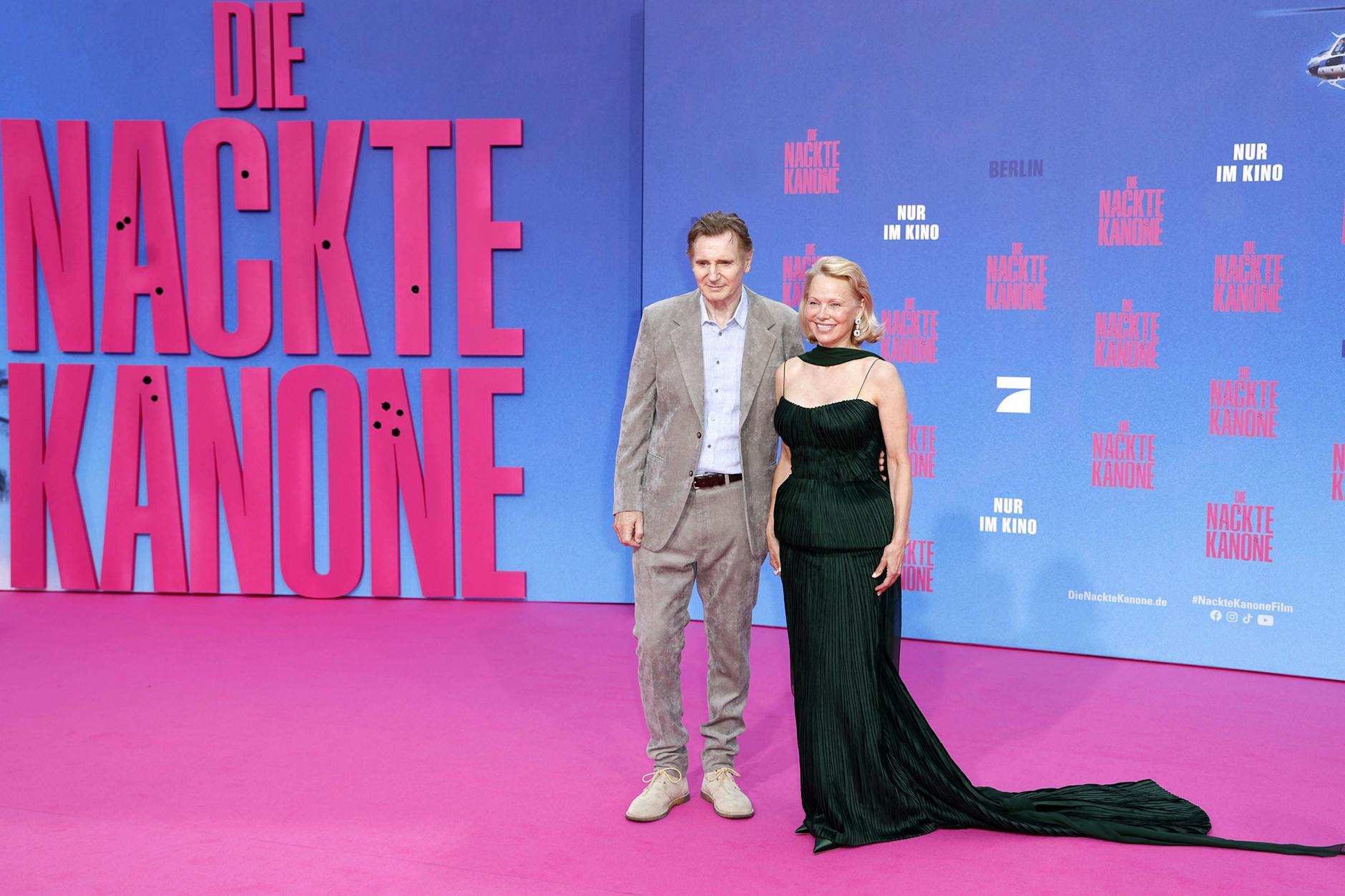 Liam Neeson und Pamela Anderson auf dem pinken Teppich in Berlin.