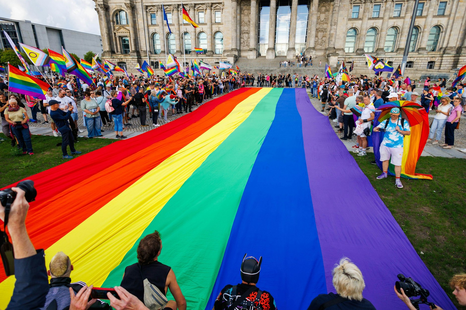 Teilnehmer einer Protestaktion rollen eine 400 400 Quadratmeter große Regenbogenflagge vor dem Bundestag aus als Protest gegen Handlungen der Bundesregierung. 