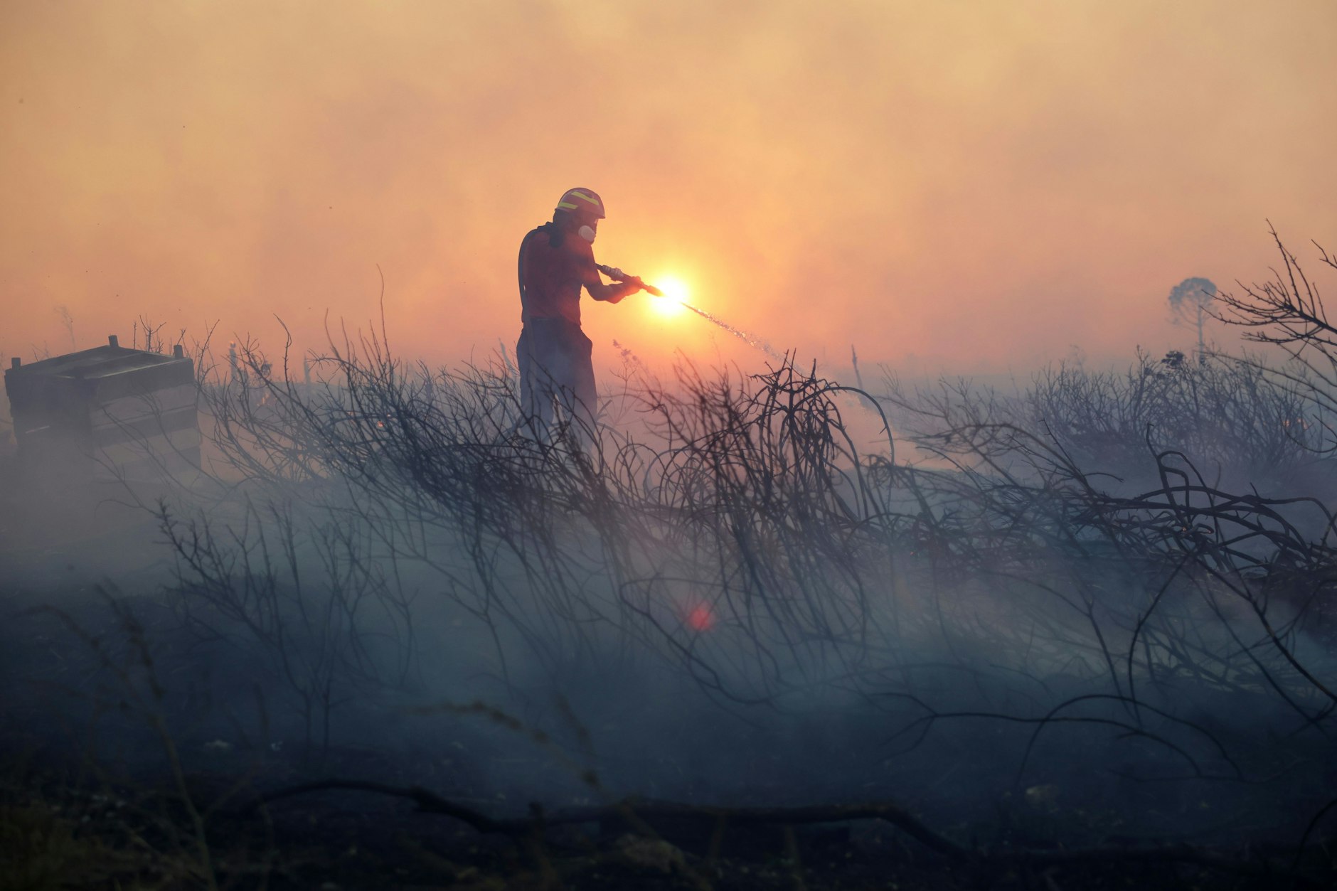 Ein Feuerwehrmann versucht, die Flammen eines Waldbrandes im nordwestlichen Vorort Kryoneri bei Athen zu löschen.