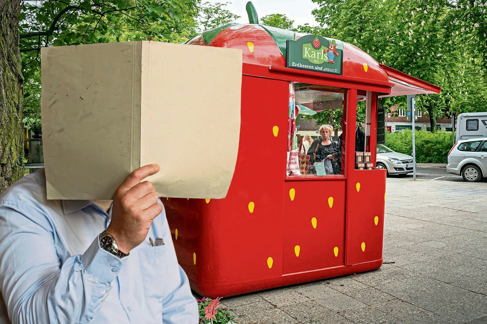 Kay H. versteckt sich hinter einem Aktendeckel. Erst soll er in so einem Erdbeer-Verkaufsstand Marmelade eingesackt haben und danach den Verkäufer mit Steinen beworfen haben.