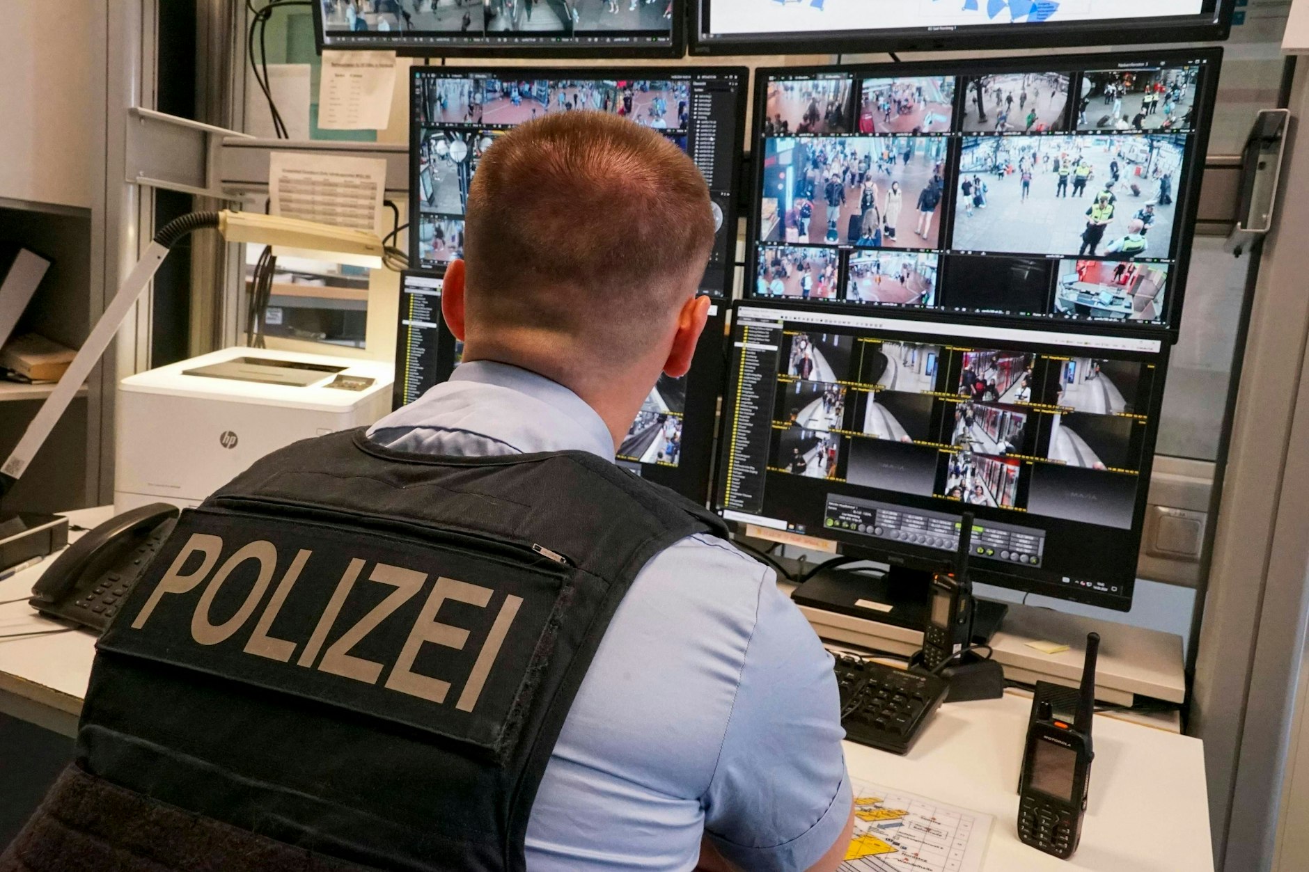Ein Polizeibeamter schaut auf Überwachungskameras am Hamburger Hauptbahnhof. Wird die Polizei bald auch die US-Software Palantir bundesweit nutzen?