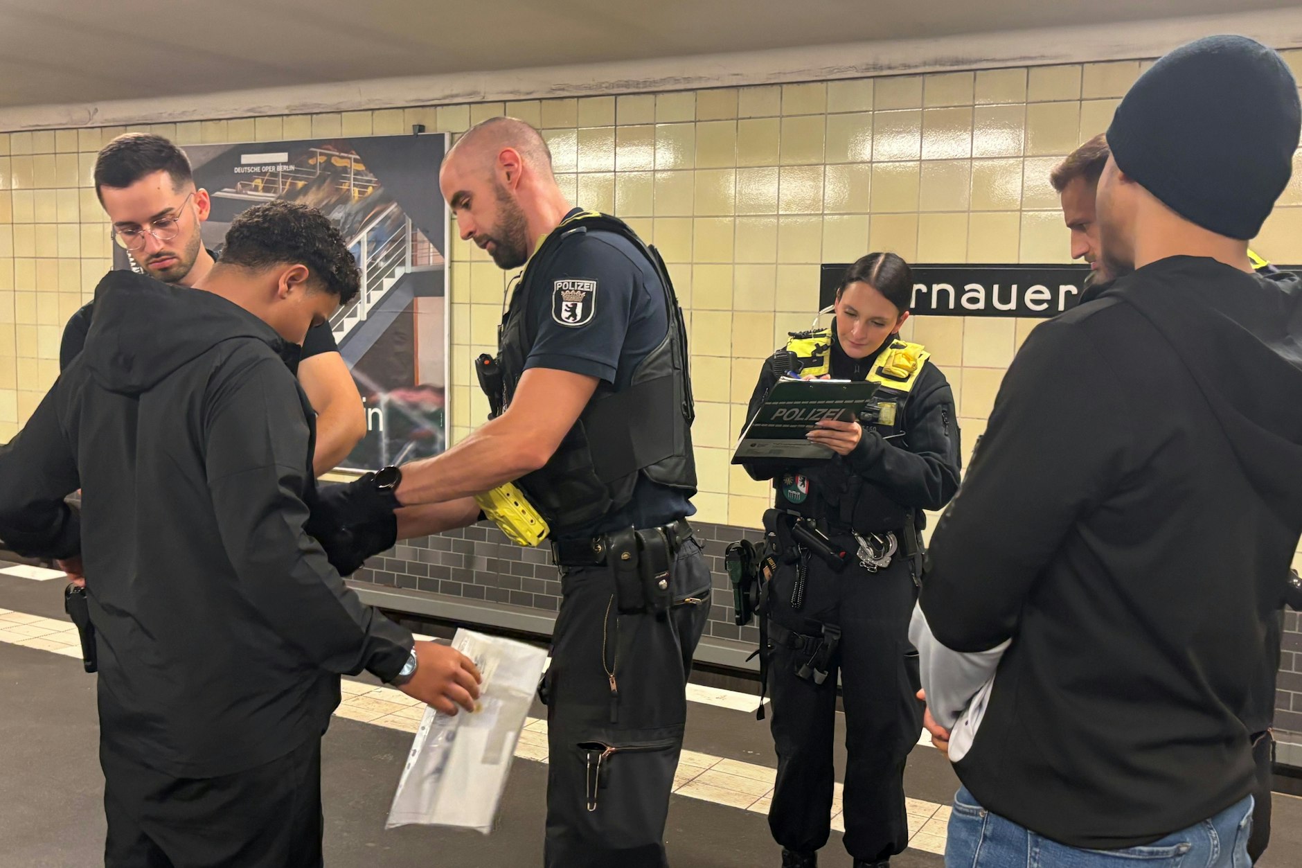 Polizisten durchsuchen in der Berliner U-Bahn Jugendliche nach Messern.