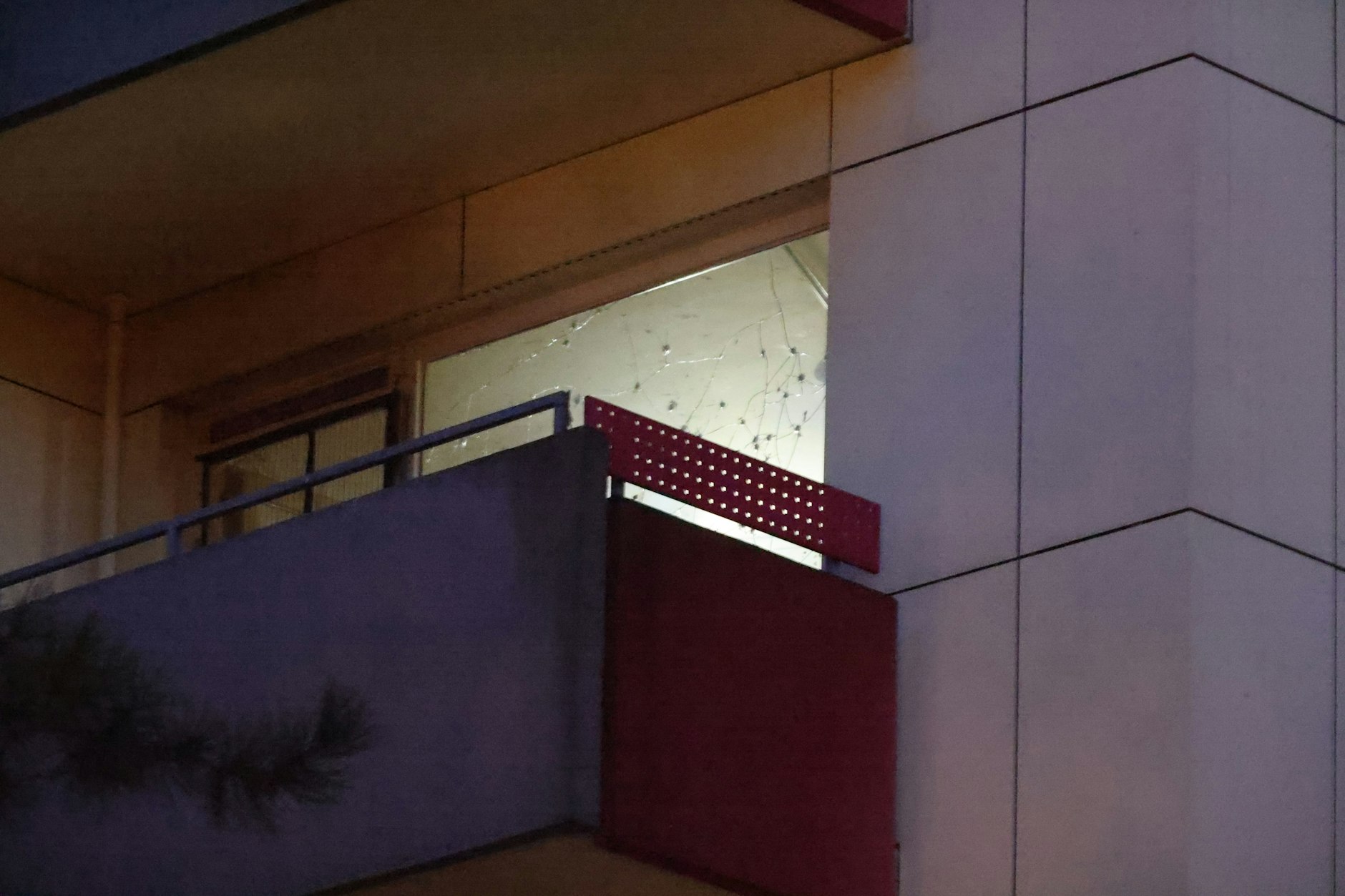 Die zerstörte Scheibe in der betreffenden Wohnung sieht aus, als ob sie von Projektilen perforiert wurde. Überall kreisförmige Einschläge, von denen lange Risse durch das Glas ausgehen.