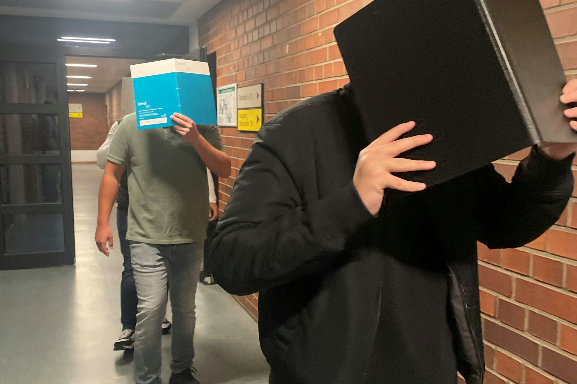 Die Angeklagten auf dem Weg ins Gericht.