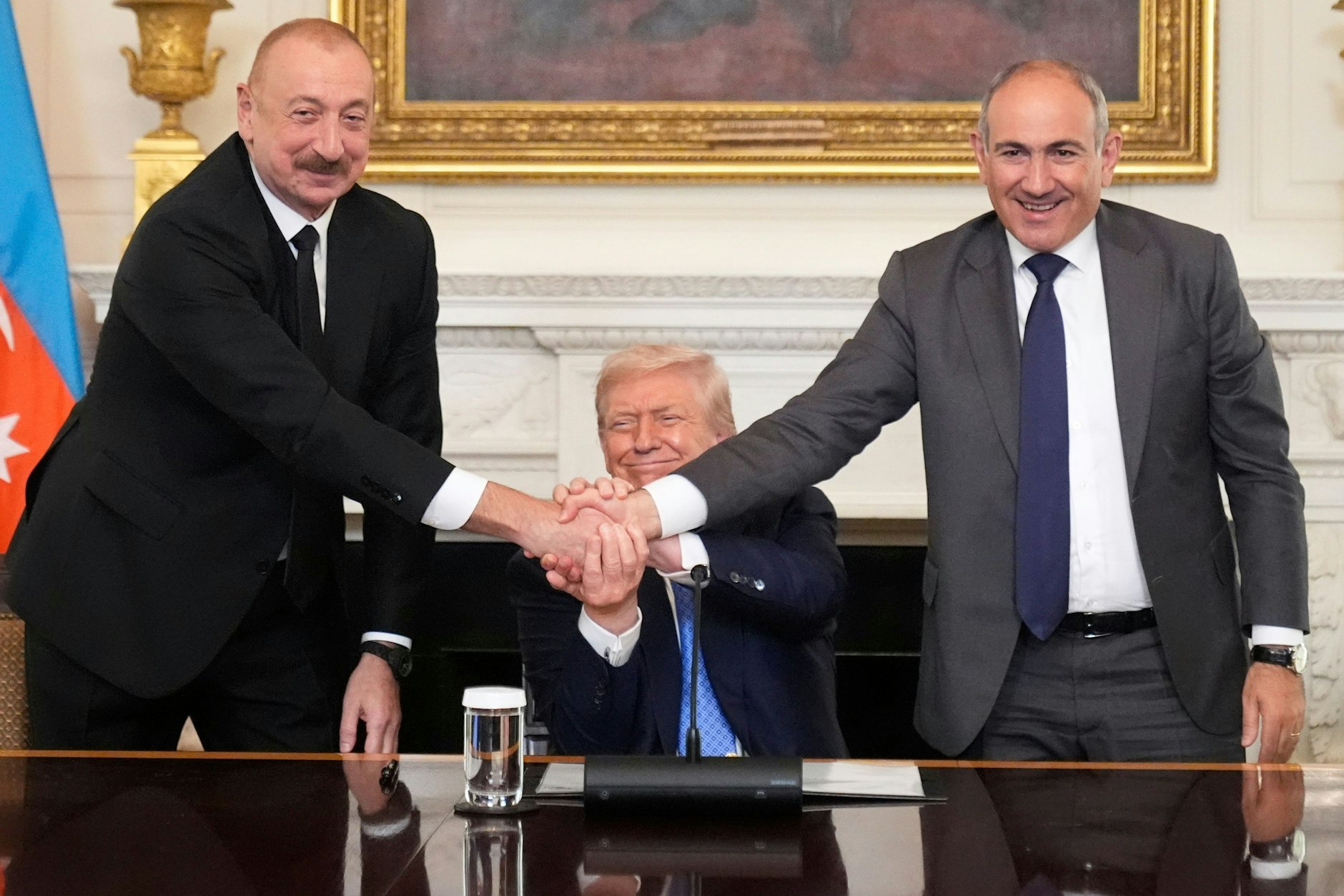 Präsident Donald Trump (M) schüttelt während einer trilateralen Unterzeichnung die Hände von Aserbaidschans Präsident Ilham Alijew (l) und Armeniens Ministerpräsident Nikol Paschinjan im State Dining Room des Weißen Hauses.