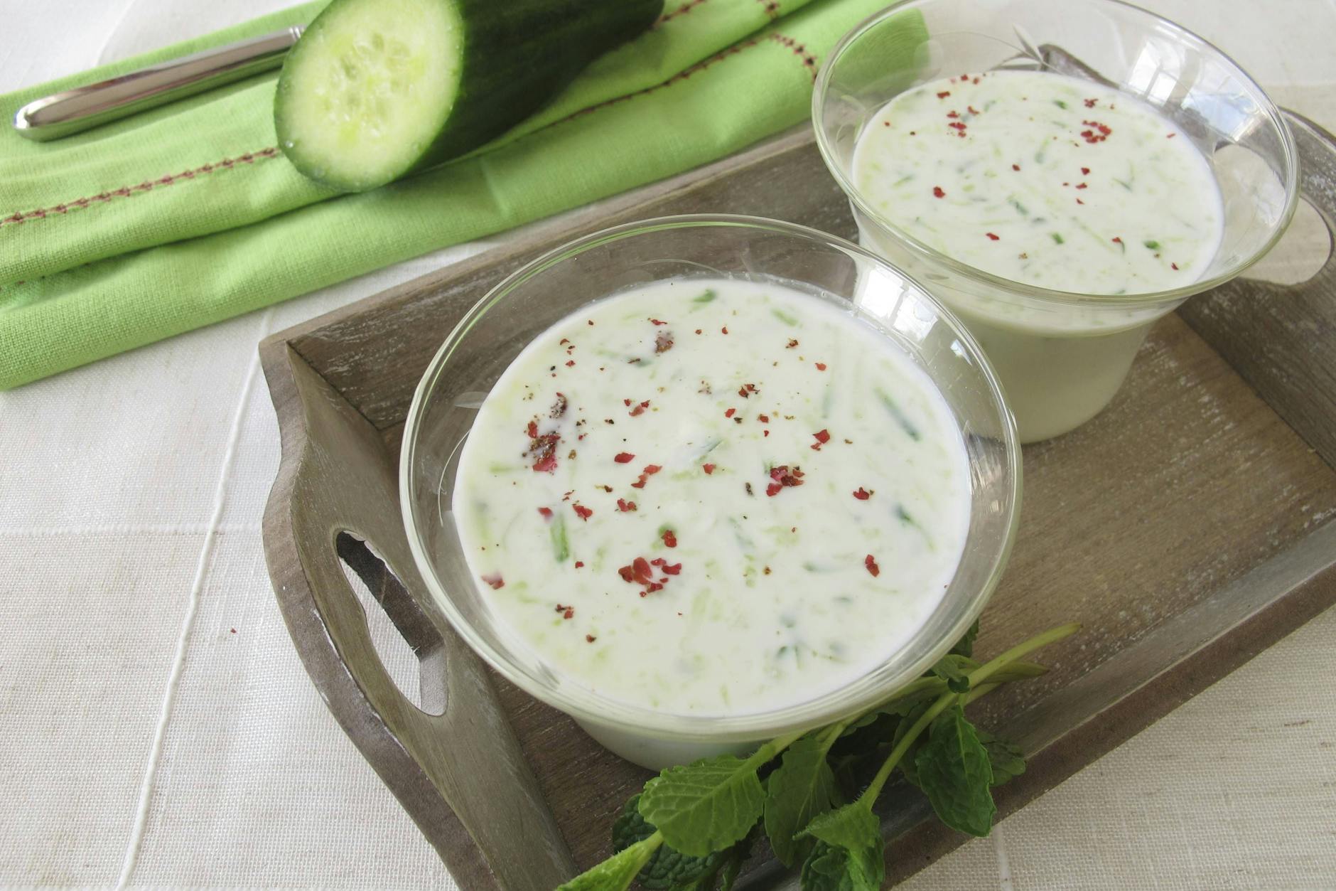 Kalte Gurkensuppe mit Frischkäse, garniert mit Chili und Minze.