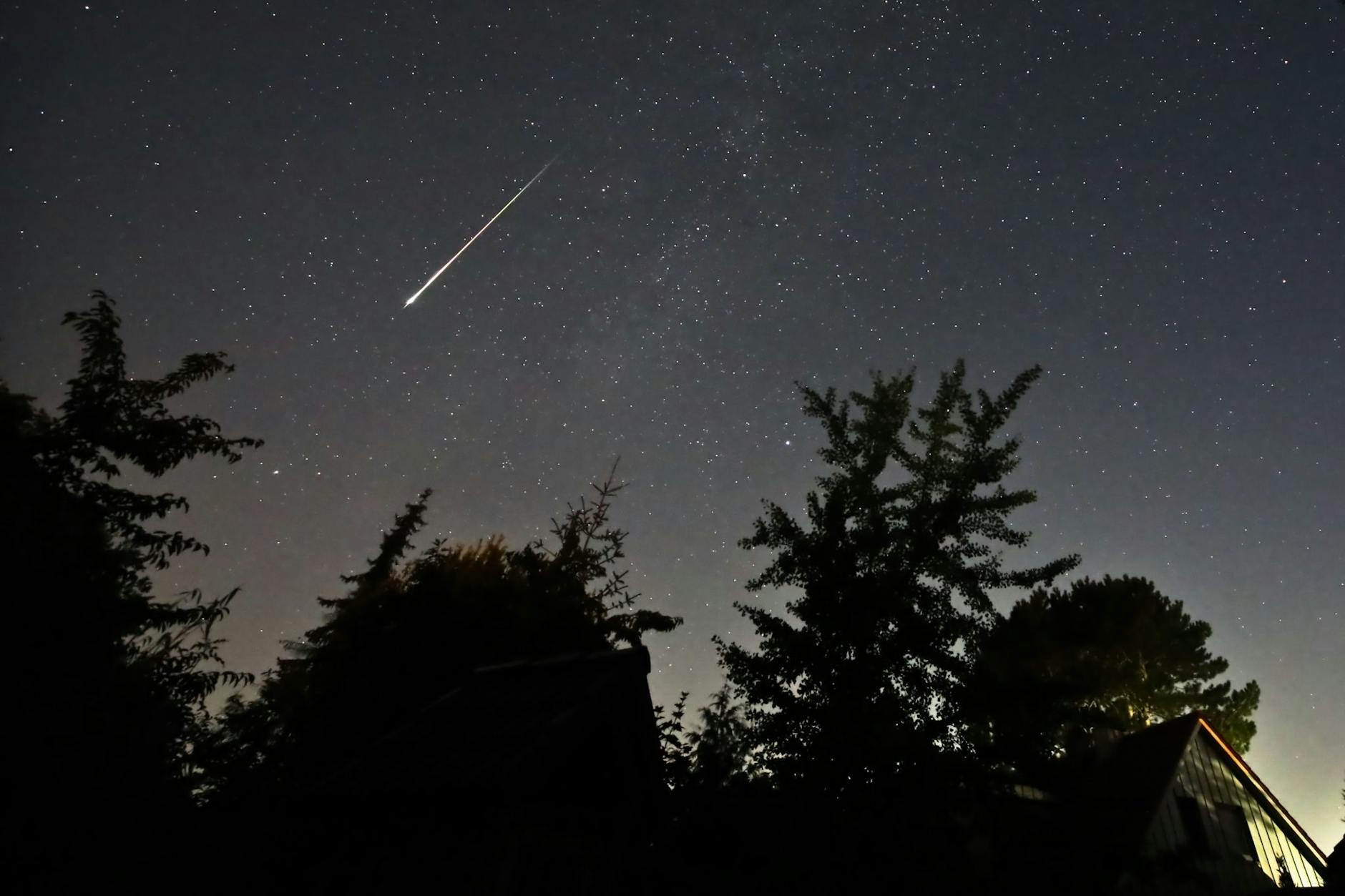 Ein Perseidenmeteor zieht über den Himmel.