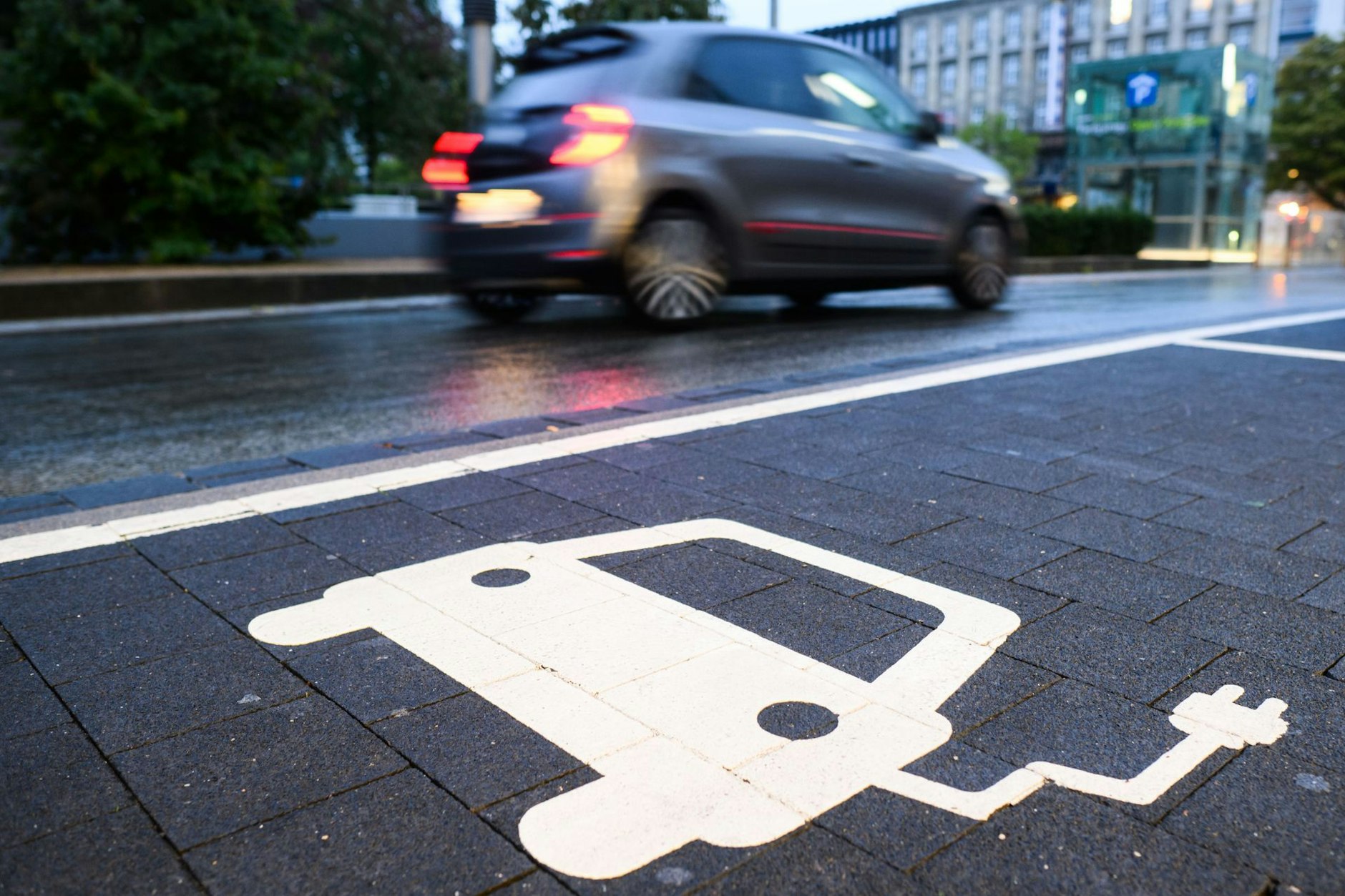 Ein Symbol markiert einen Parkplatz an einer Ladesäule für Elektroautos.