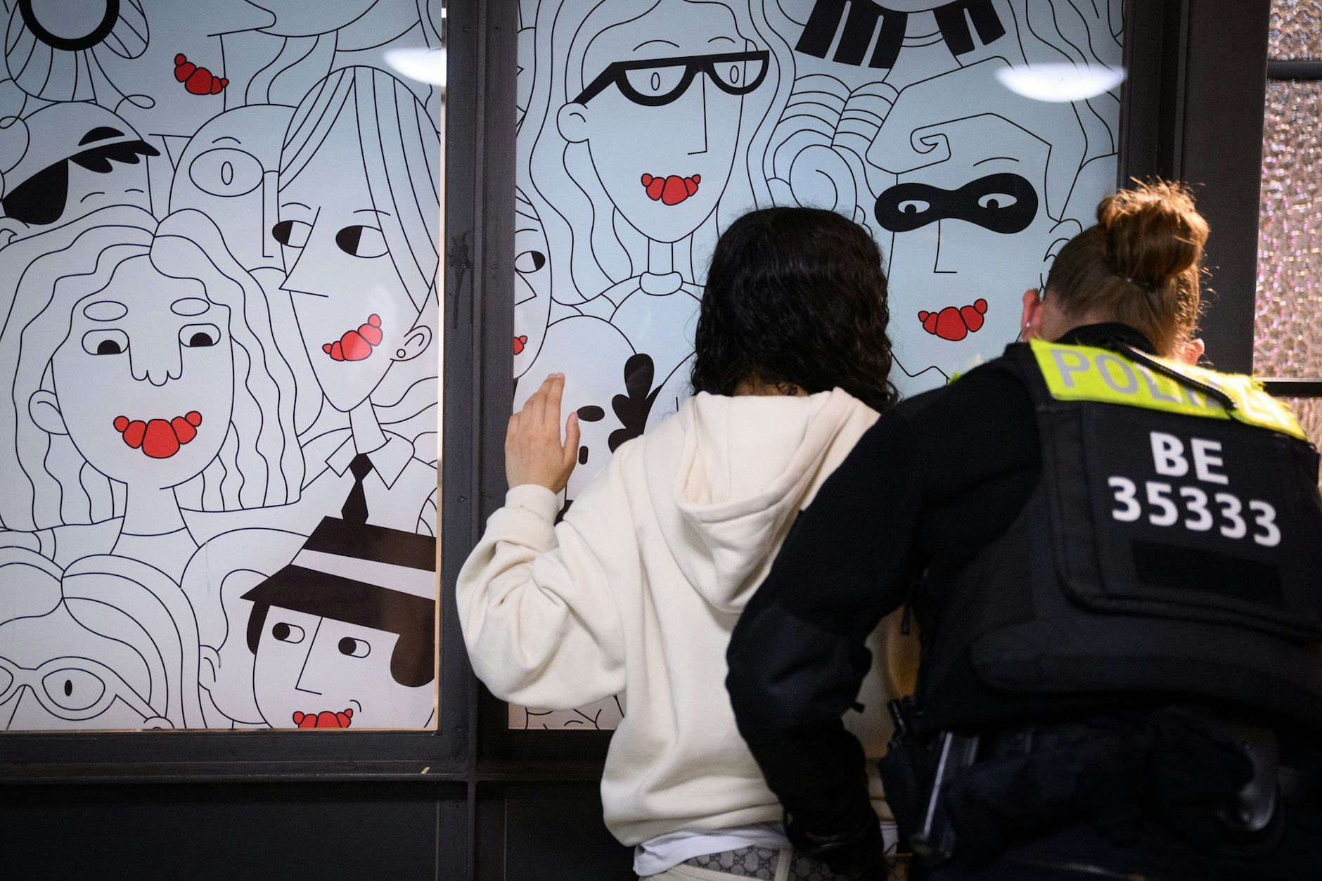Eine Polizeibeamtin durchsucht am Bahnhof Alexanderplatz zu Beginn des Waffenverbots in Berliner U-Bahnen eine junge Frau.