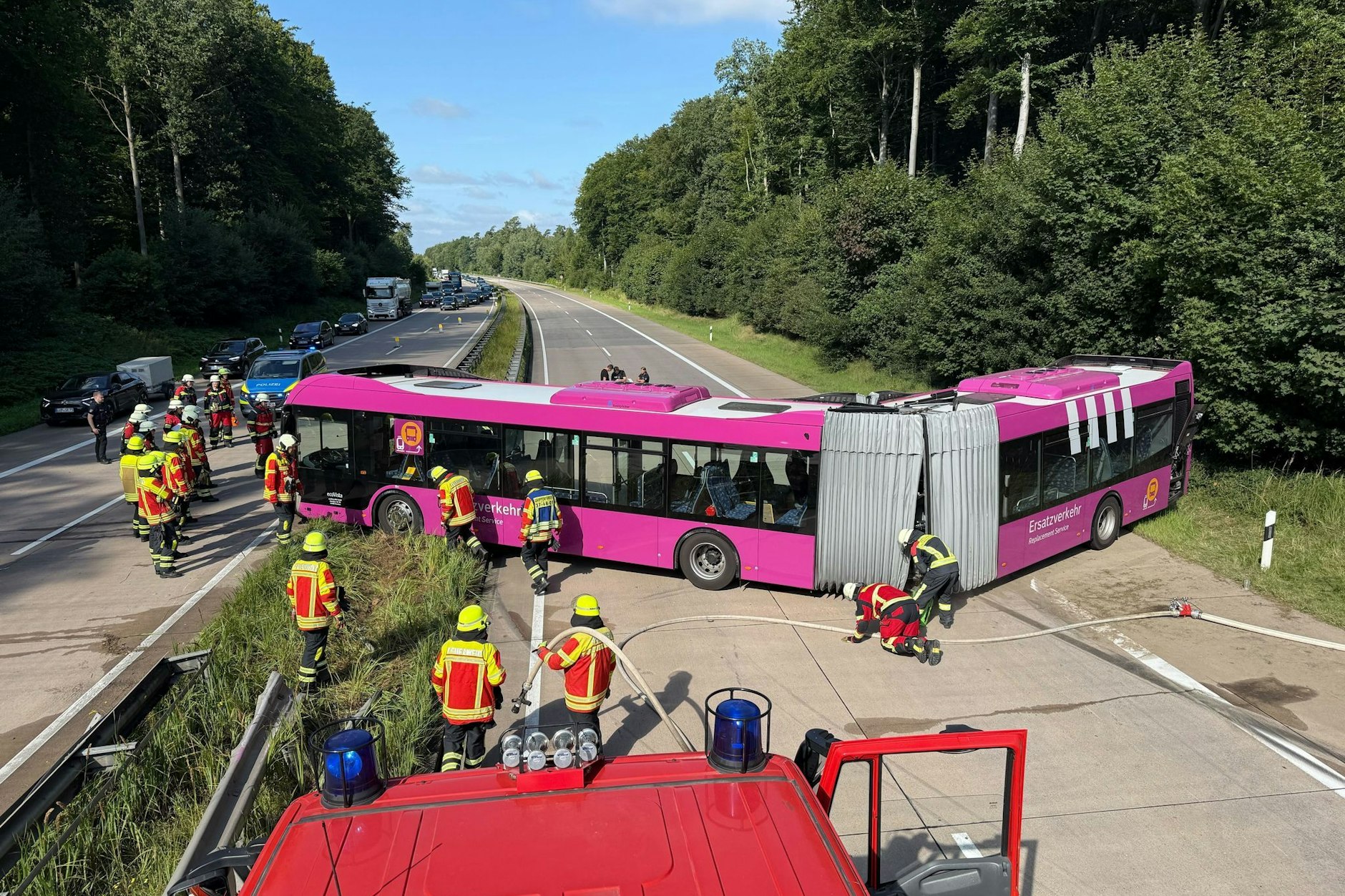 Rettungskräfte, Feuerwehr und Polizei sind an der Unfallstelle im Einsatz, wo ein Bus nach einem Unfall quer auf der Fahrbahn der A24 steht.