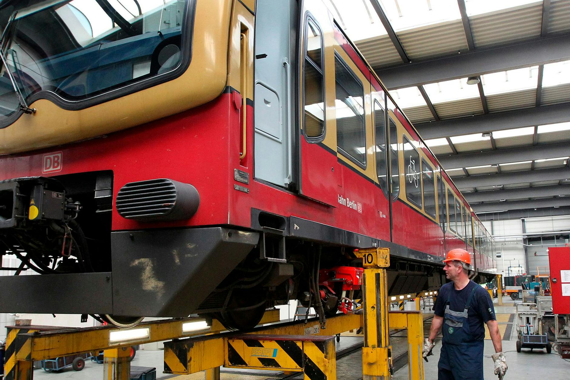 Ein Mitarbeiter der S-Bahn kontrolliert einen Zug der Baureihe 481 in der Werkstatt.