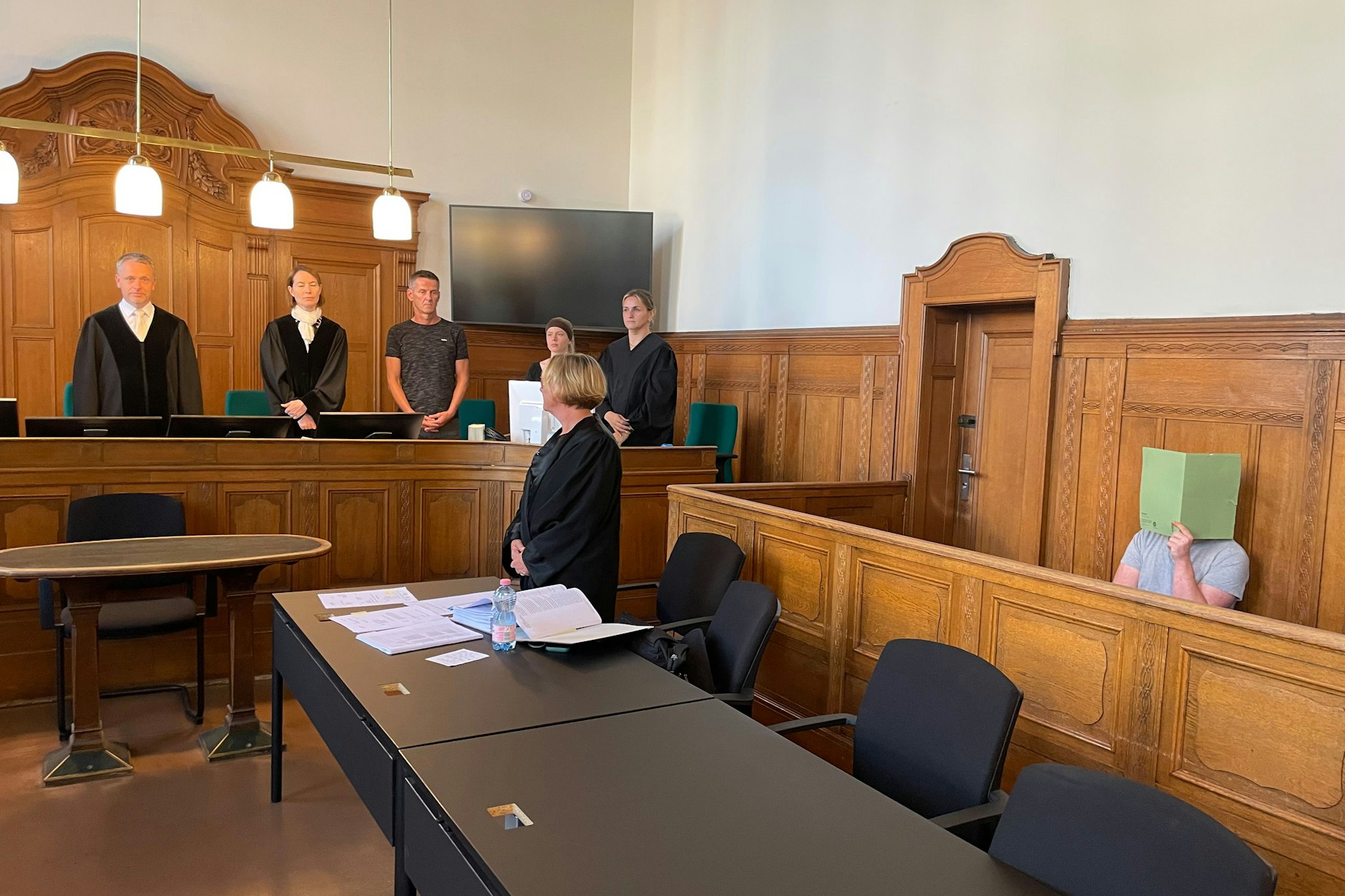 Der Angeklagte Tom-Maximilian Y. (20/r.) verdeckt vor Gericht sein Gesicht.