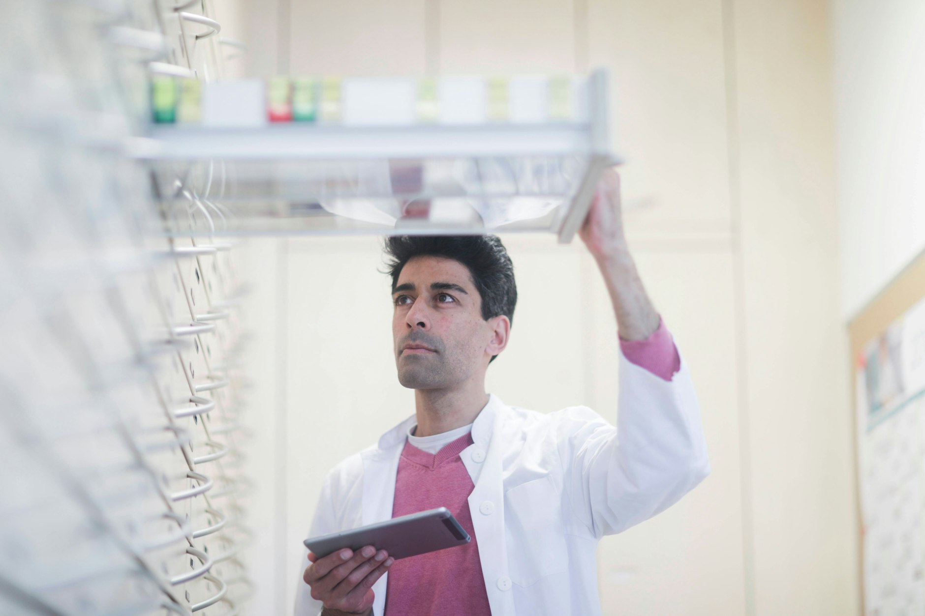 Ein Apotheker sucht ein Medikament heraus.