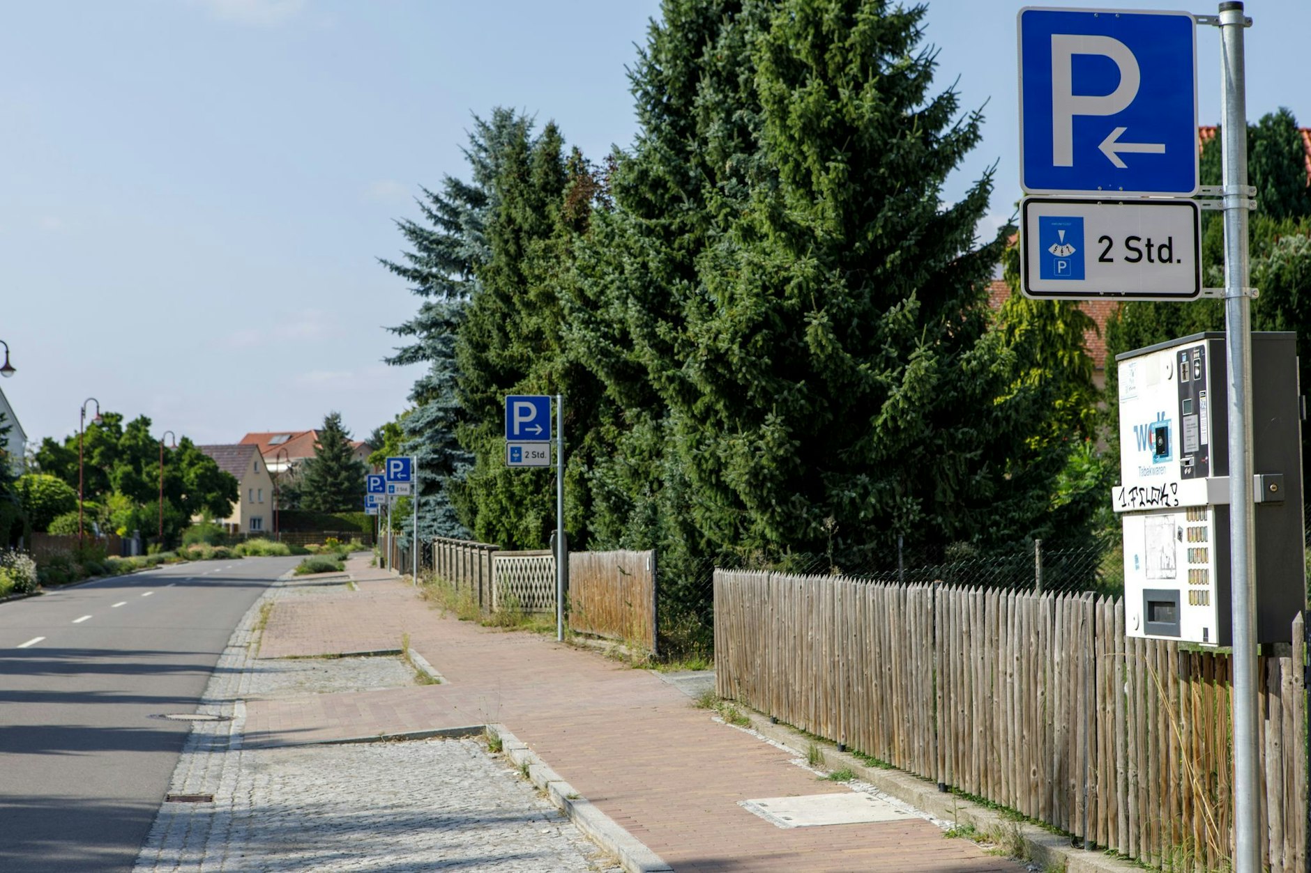 16 Parkschilder stehen an einem Parkstreifen mit Zeitbegrenzung auf 400 Metern.