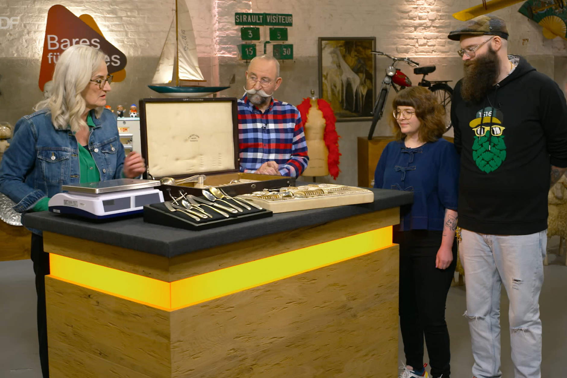 Horst Lichter, Expertin Friederike Werner und die beiden Kandidaten Anja Arneth und Sebastian Fischer  bei der Expertise. sie brachten ein riesiges Besteck-Set mit zu Bares für Rares.