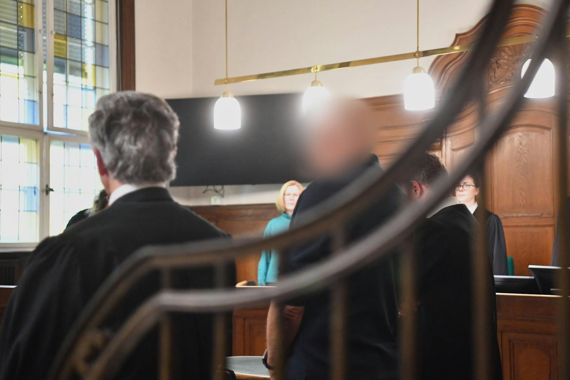 Der Angeklagte steht im Gerichtssaal des Kriminalgerichts beim Prozessauftakt. Der Narkosearzt soll für den Tod einer 59-jährigen Patientin verantwortlich sein.