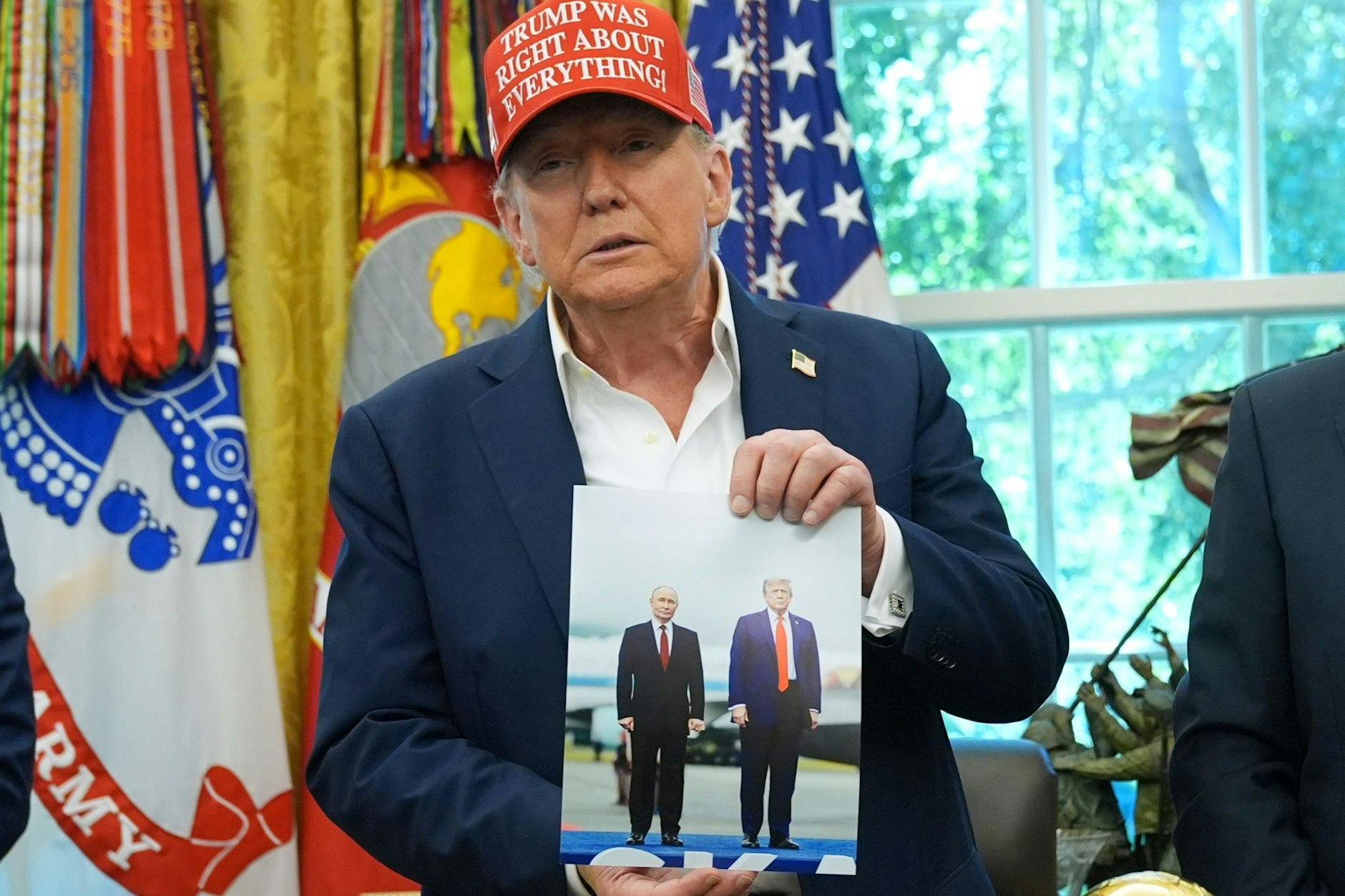 US-Präsident Donald Trump hält am Freitag ein Foto von sich mit dem russischen Präsidenten Wladimir Putin während einer Ankündigung im Oval Office des Weißen Hauses.