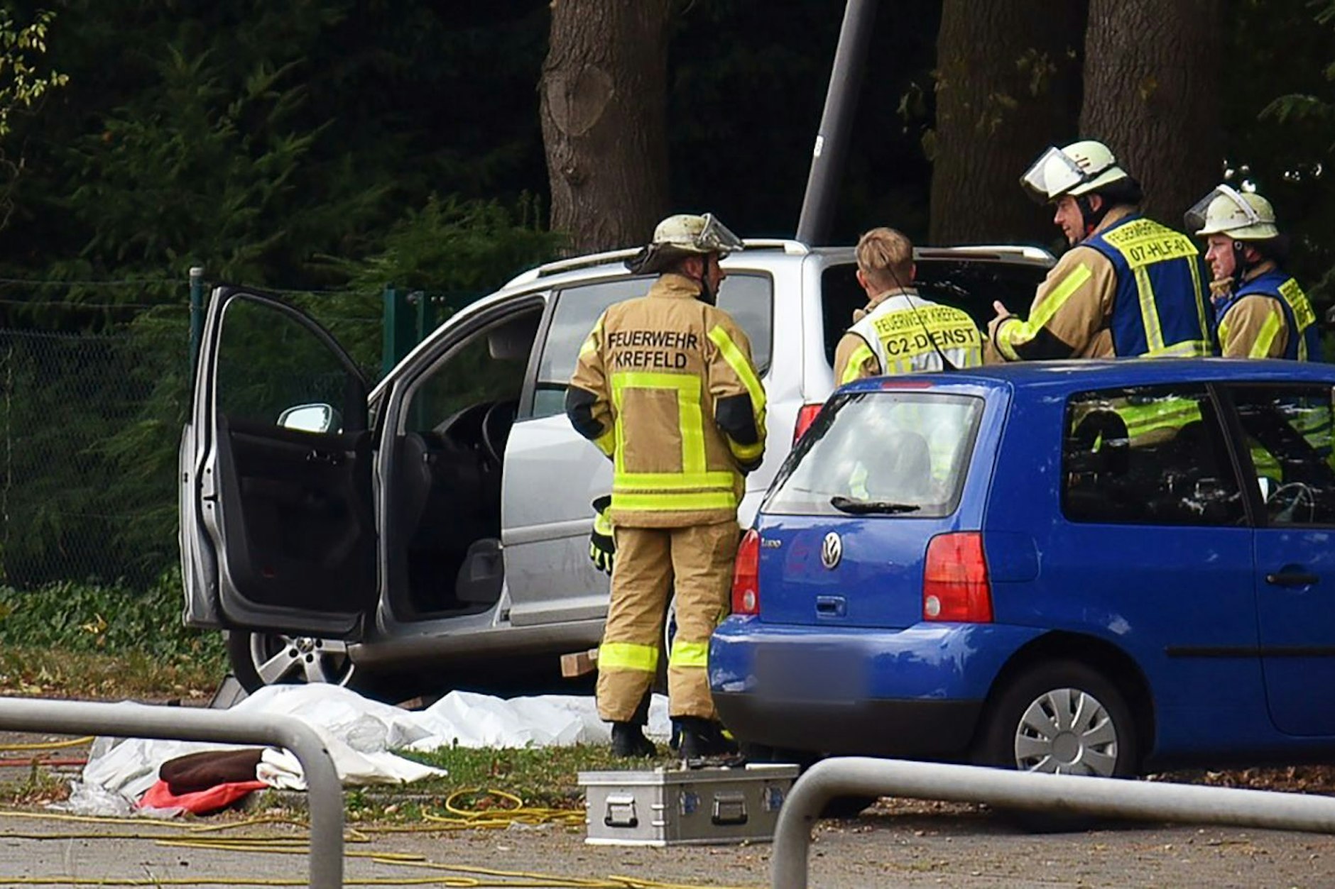 Kräfte der Feuerwehr sind am Unfallort auf dem Parkplatz des Friedhofs im Einsatz.