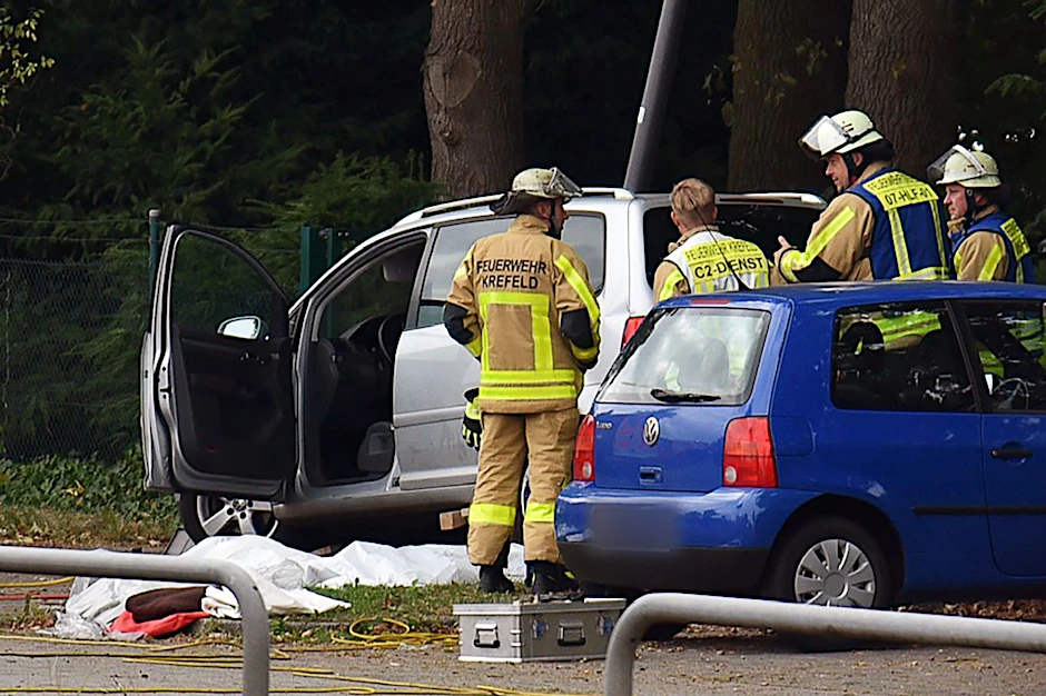 Kräfte der Feuerwehr sind am Unfallort auf dem Parkplatz des Friedhofs im Einsatz.