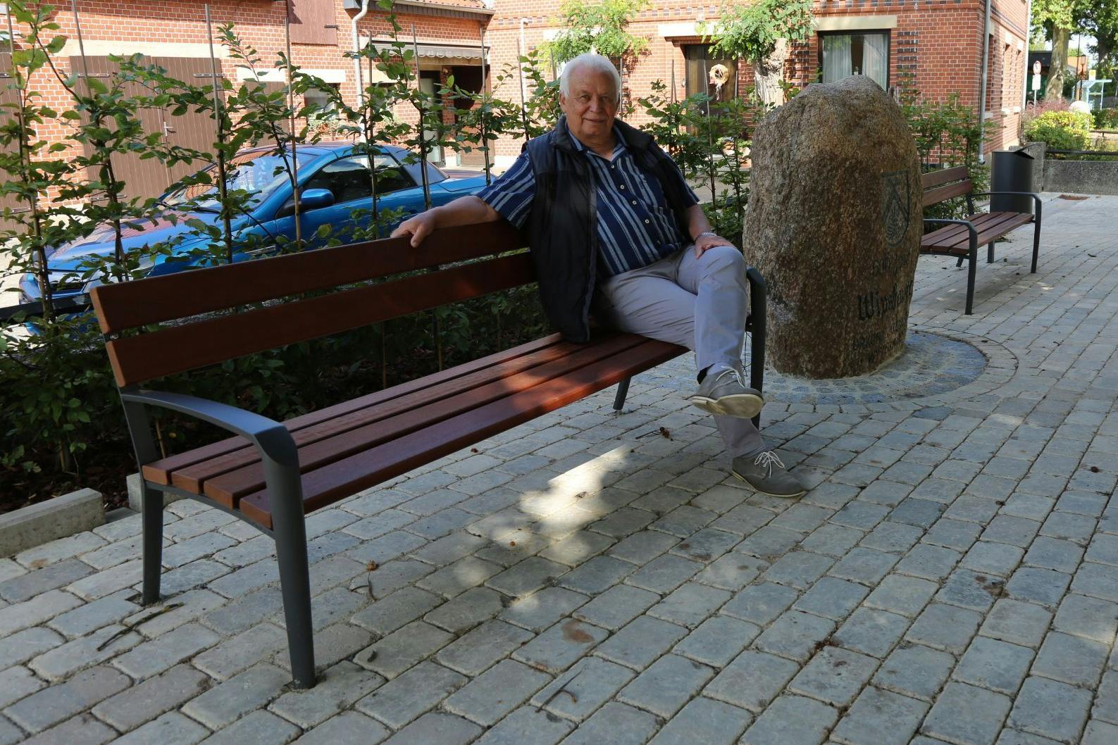 Jetzt sind sie aufgestellt: Ortsbürgermeister Günter Meyer sitzt auf einer der neuen Bänke des Dorfplatzes von Wipshausen.