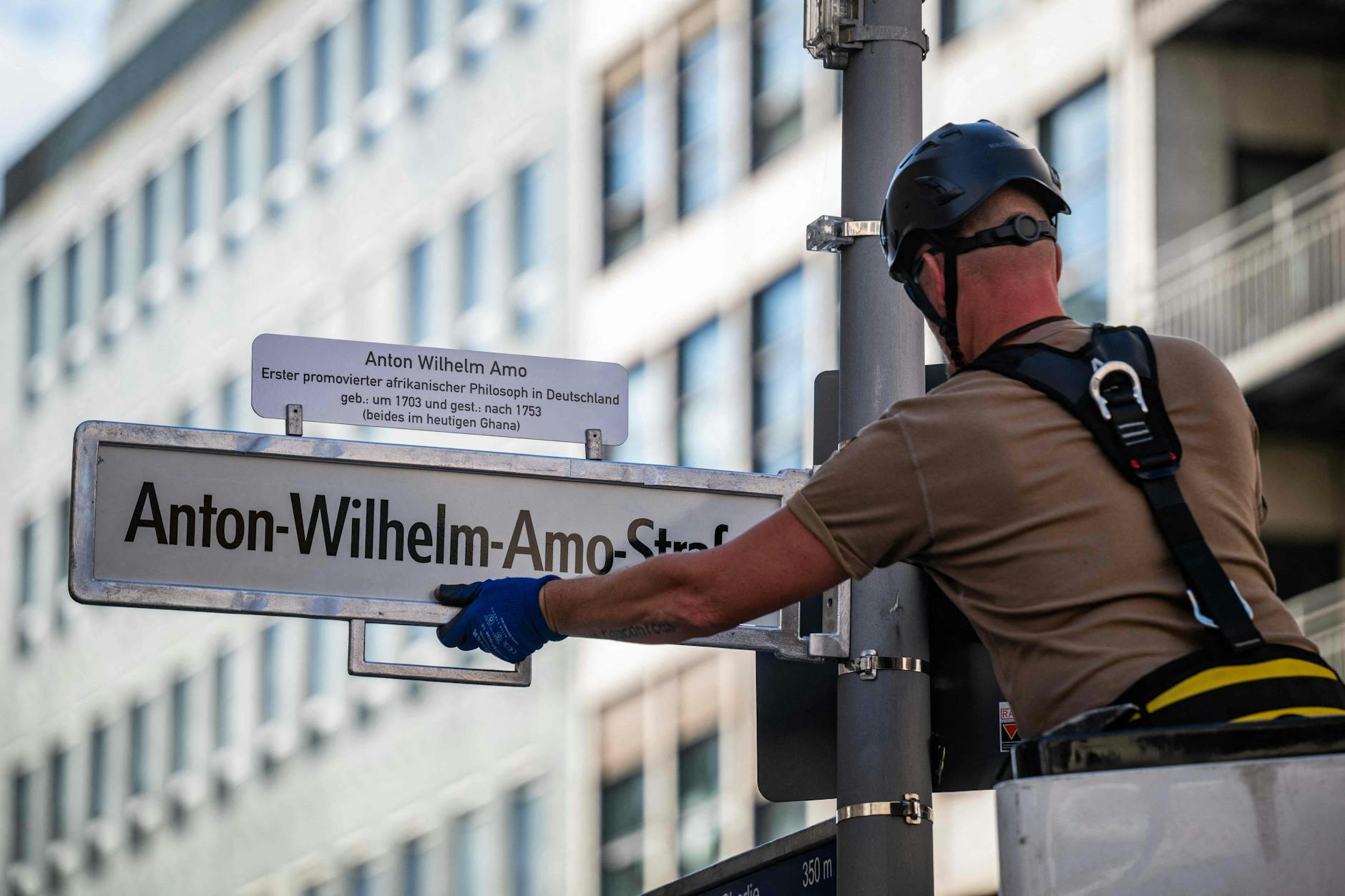 Ein Arbeiter schraubt in der einstigen Mohrenstraße eines von 30 neuen Straßenschildern an. 7500 Euro kostet die Umbenennung das Bezirksamt Berlin-Mitte.
