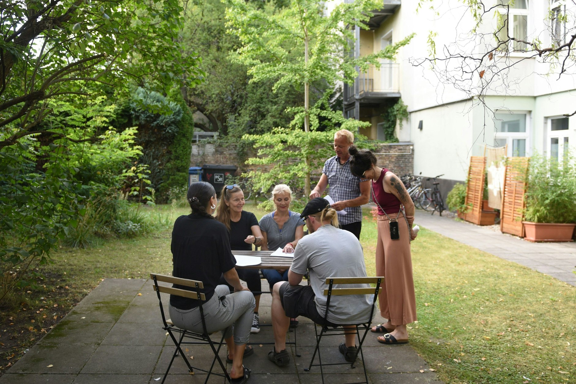 Anwohner im Hinterhofgarten ihres Gründerzeitbaus in Pankow – die Idylle ist bedroht: Direkt nebenan soll ein Hotel entstehen.