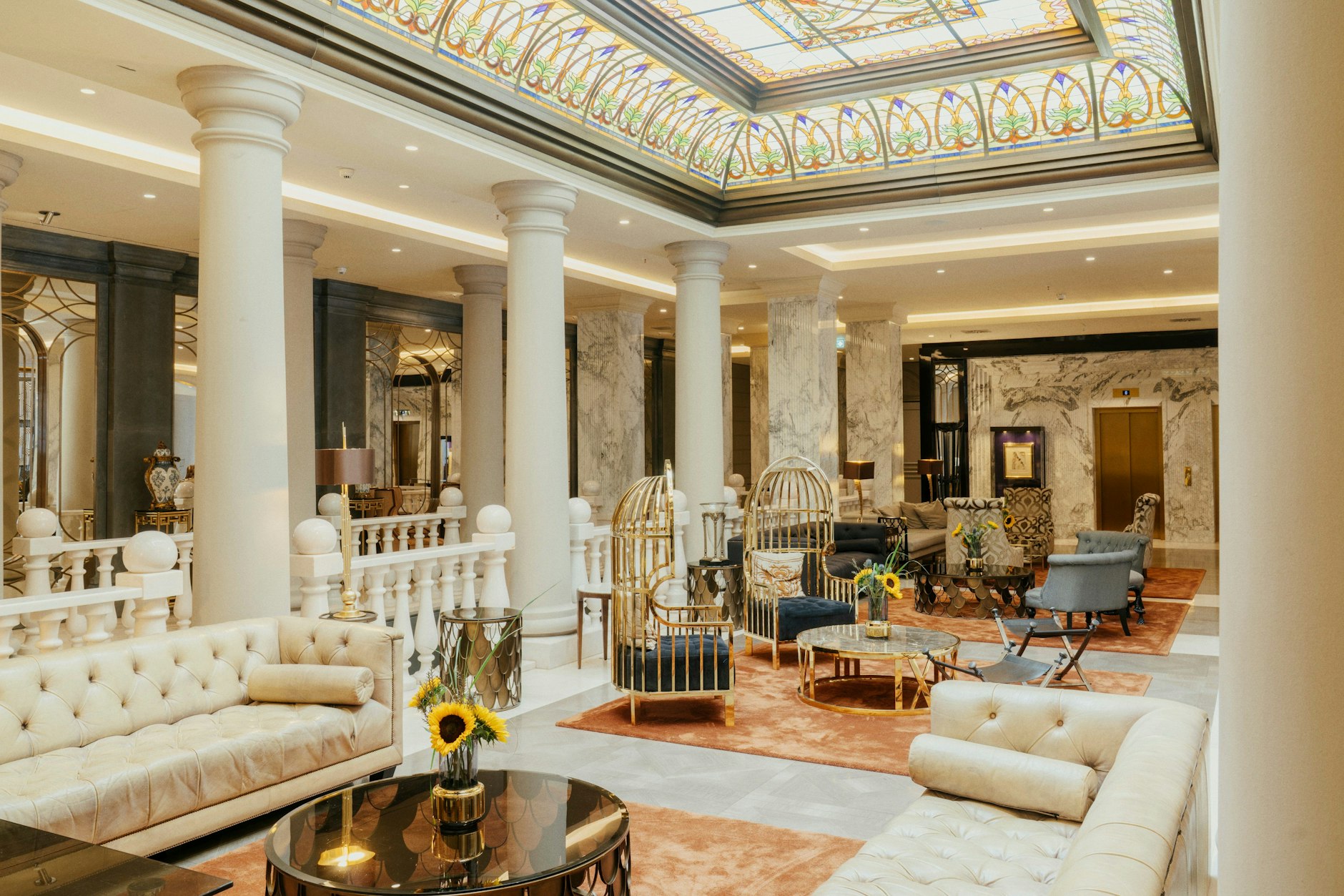 Chesterfield-Sofas auf spiegelglatten Marmorböden, goldene Couchtische, ornamentreiche Stoffe.