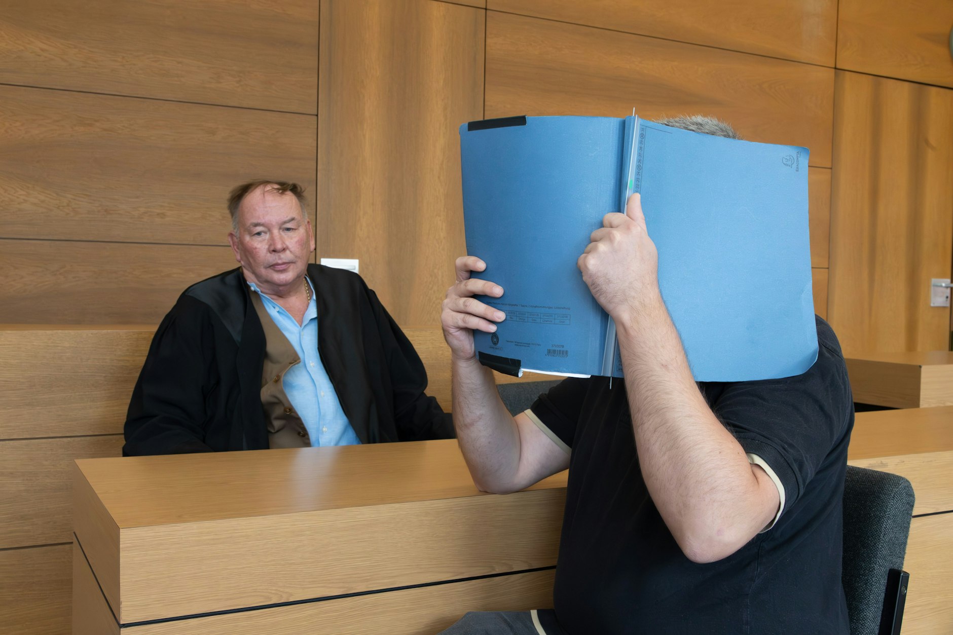 Der Angeklagte sitzt neben seinem Anwalt in Berlin vor Gericht.