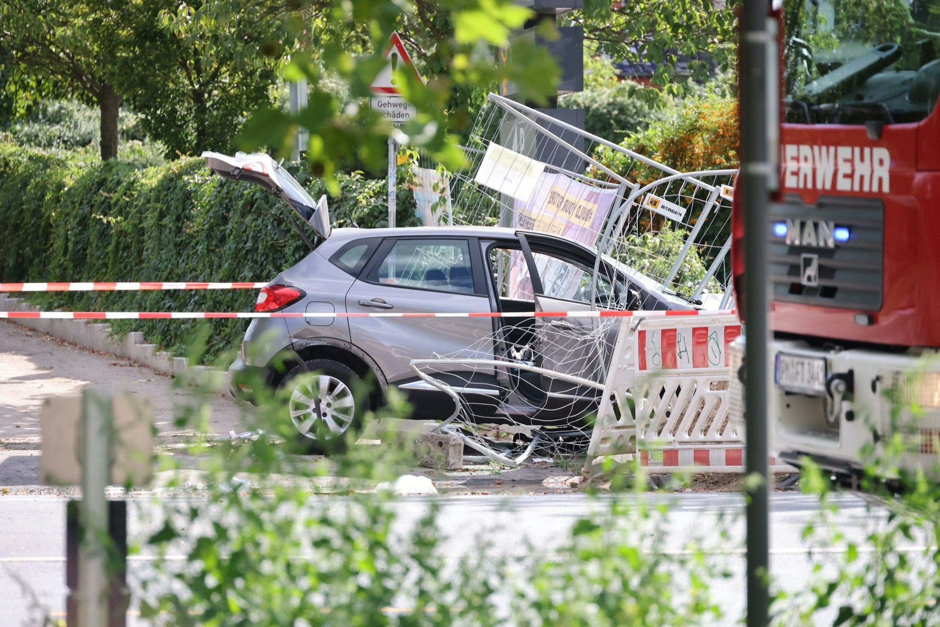 Der silberne Kleinwagen steht stark beschädtigt am Straßenrand.