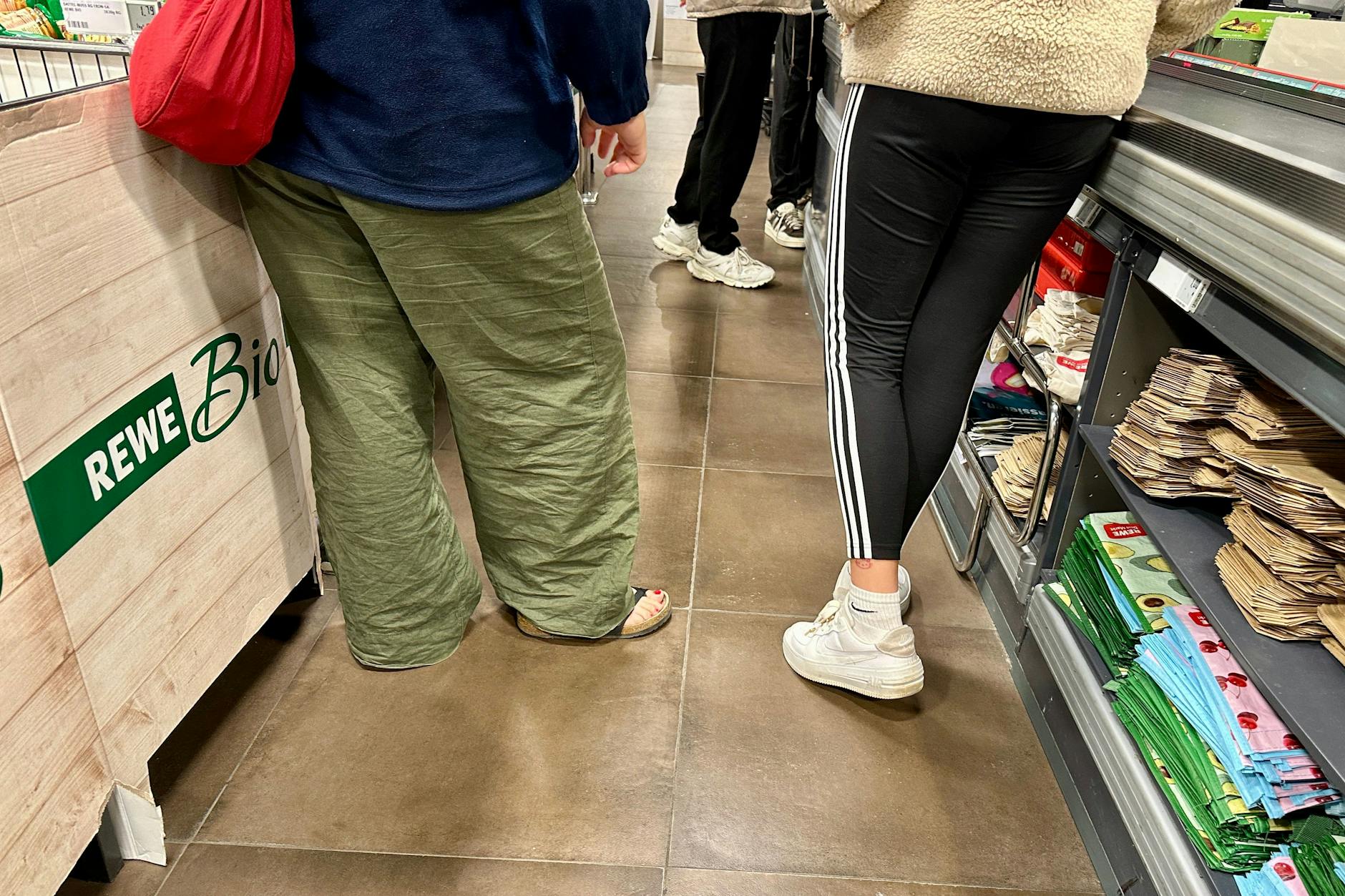 Schön isses nicht: Beinkleider der Kundschaft an einer Kasse in Mitte.