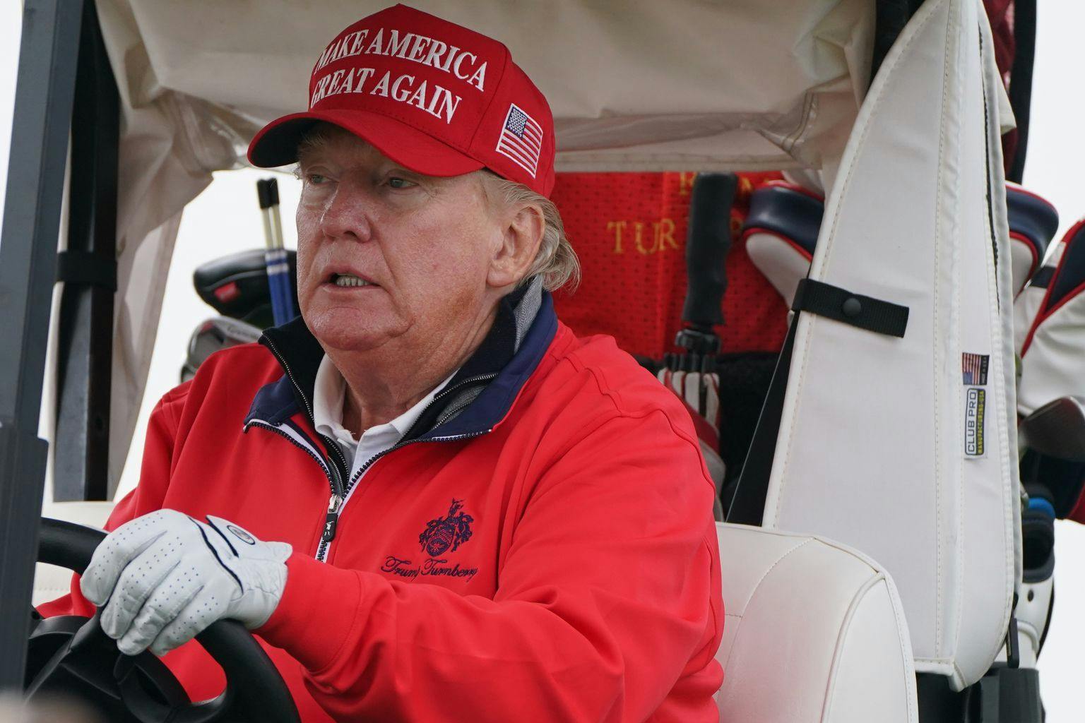Donald Trump fährt im Jahr 2023 einen Golfwagen.