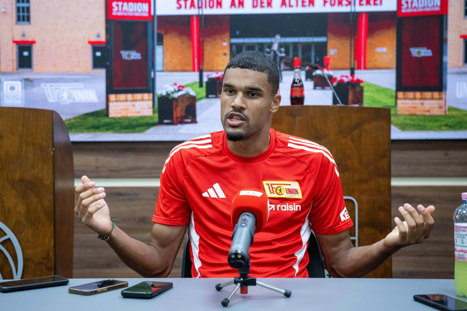 Danilho Doekhi hebt im Gespräch beide Arme, um seinen Aussagen mehr Gewicht zu verleihen.