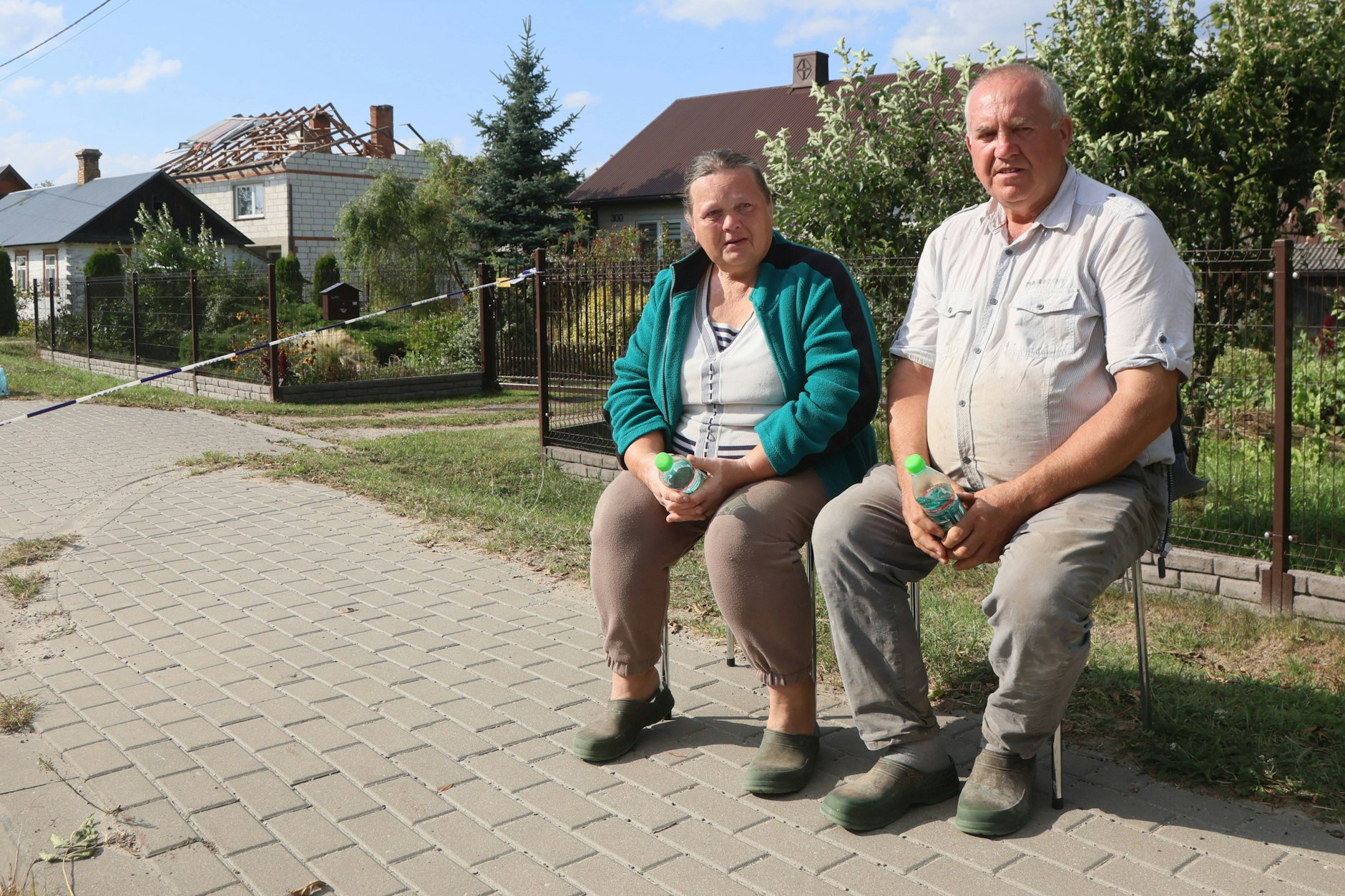 Alicja Wesolowska und ihr Mann Tomasz Wesolowski sitzen vor ihrem Grundstück. In der Nacht zu Mittwoch stürzte eine der russischen Drohnen in ihr Haus. Nun stehen sie vor den Trümmern ihrer Existenz.