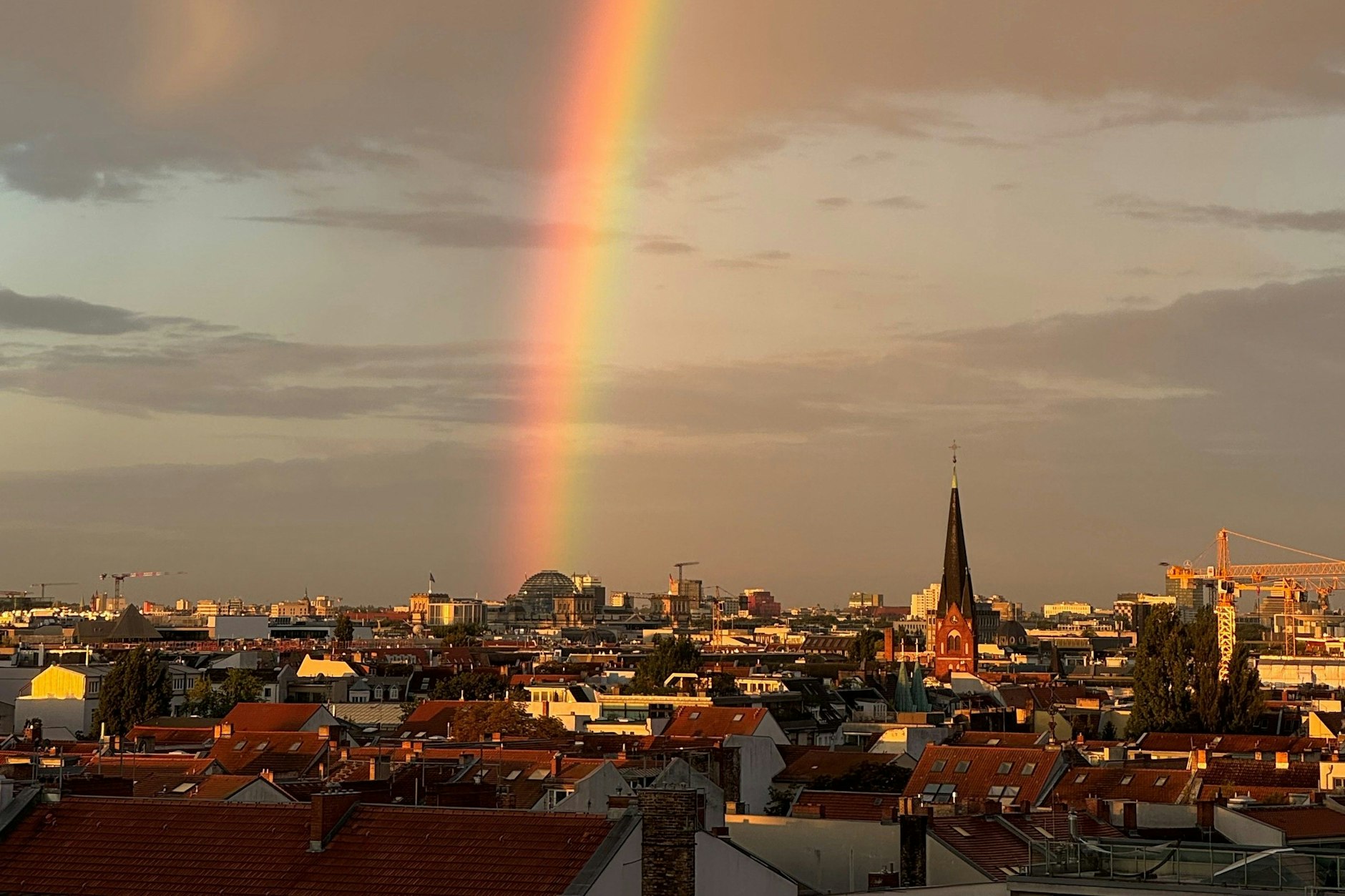 Auf dem Foto scheint der Regenbogen am Reichstag zu enden. Der Legende nach liegt am Ende ein Schatz.
