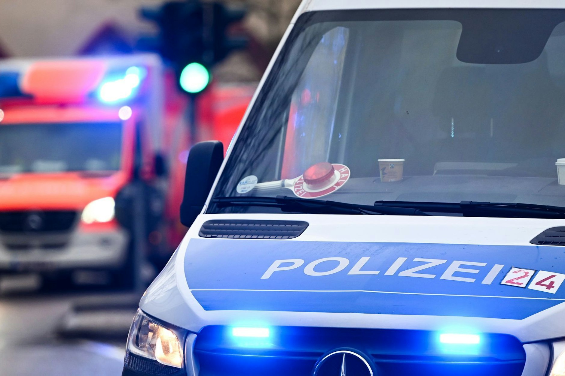 Ein Polizeiauto und ein Rettungswagen mit Blaulicht.