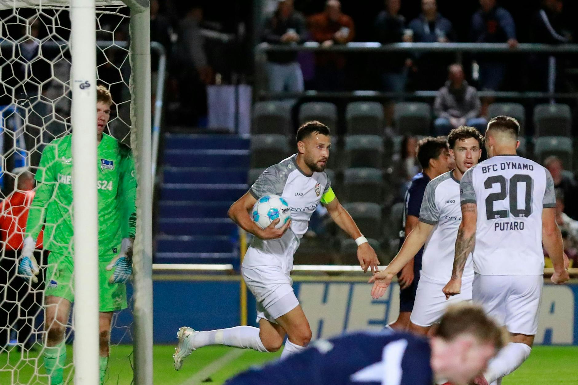 Rufat Dadashov hat sich nach seinem 2:2 den Ball geschnappt, seine Kollegen vom BFC Dynamo feiern das Tor.