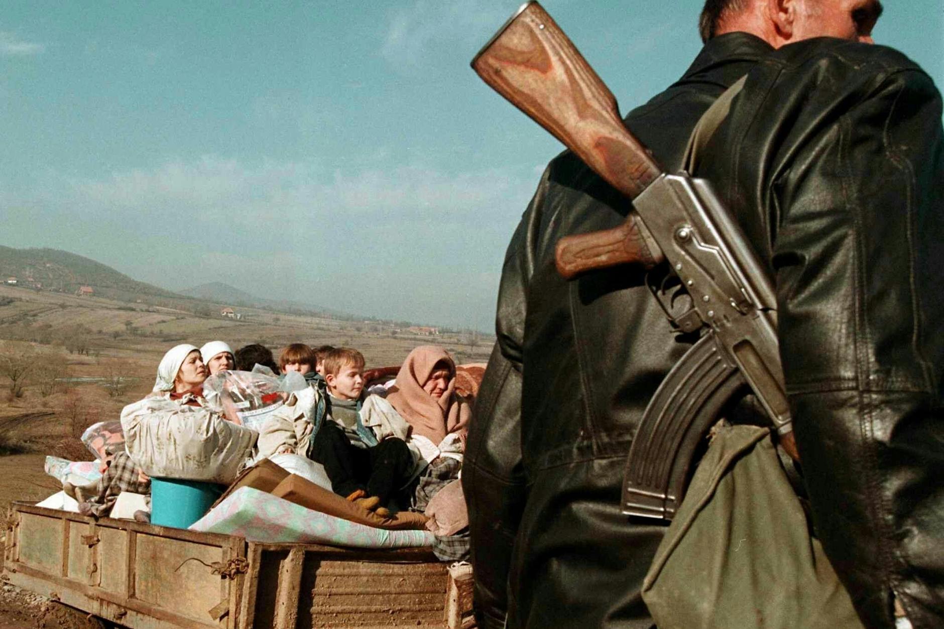 Ein Mitglied der UÇK eskortiert flüchtende Dorfbewohner im Kosovo 1999