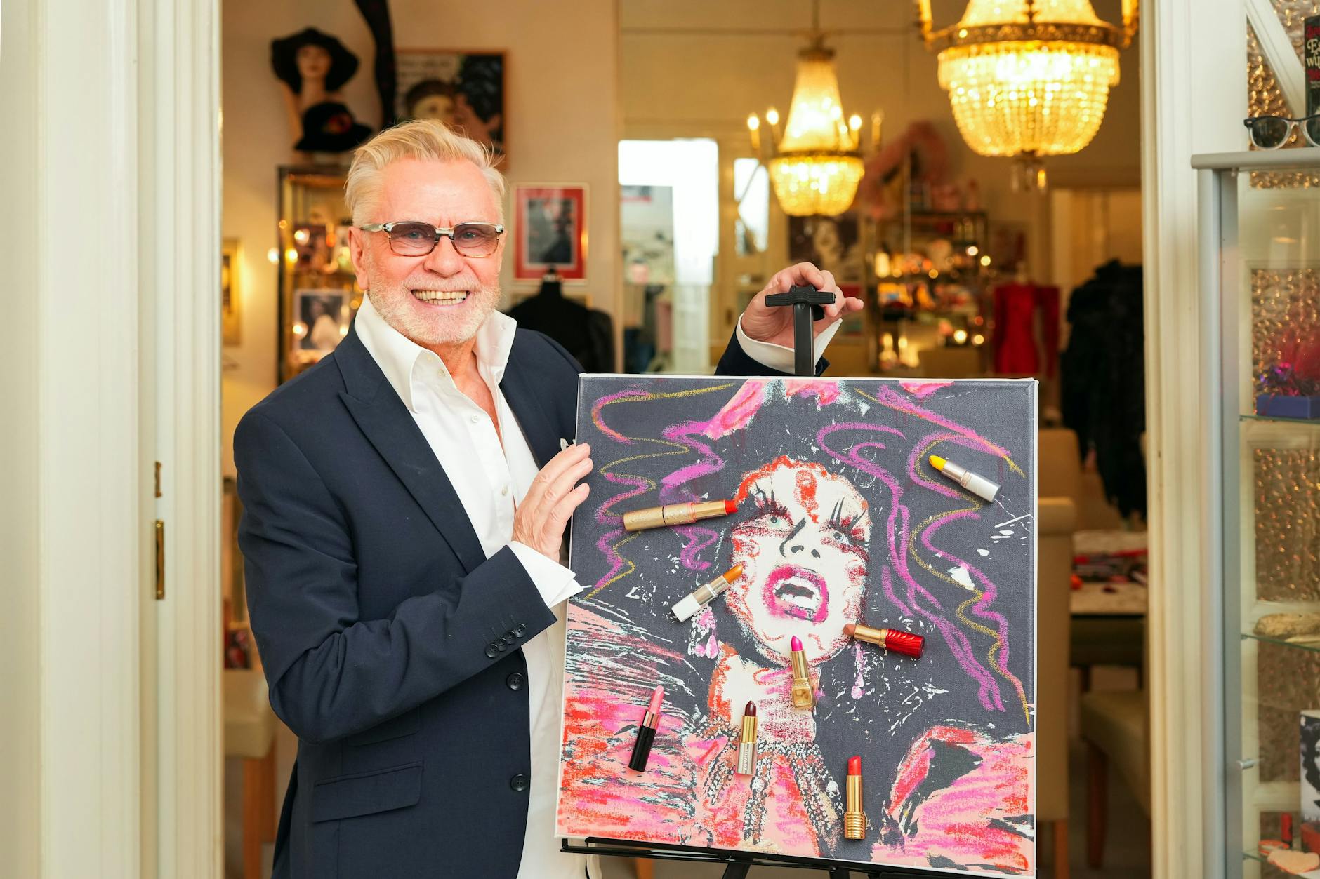 Schönheitsexperte René Koch zeigt stolz sein mit Lippenstiften gemaltes Bild „Happy“.