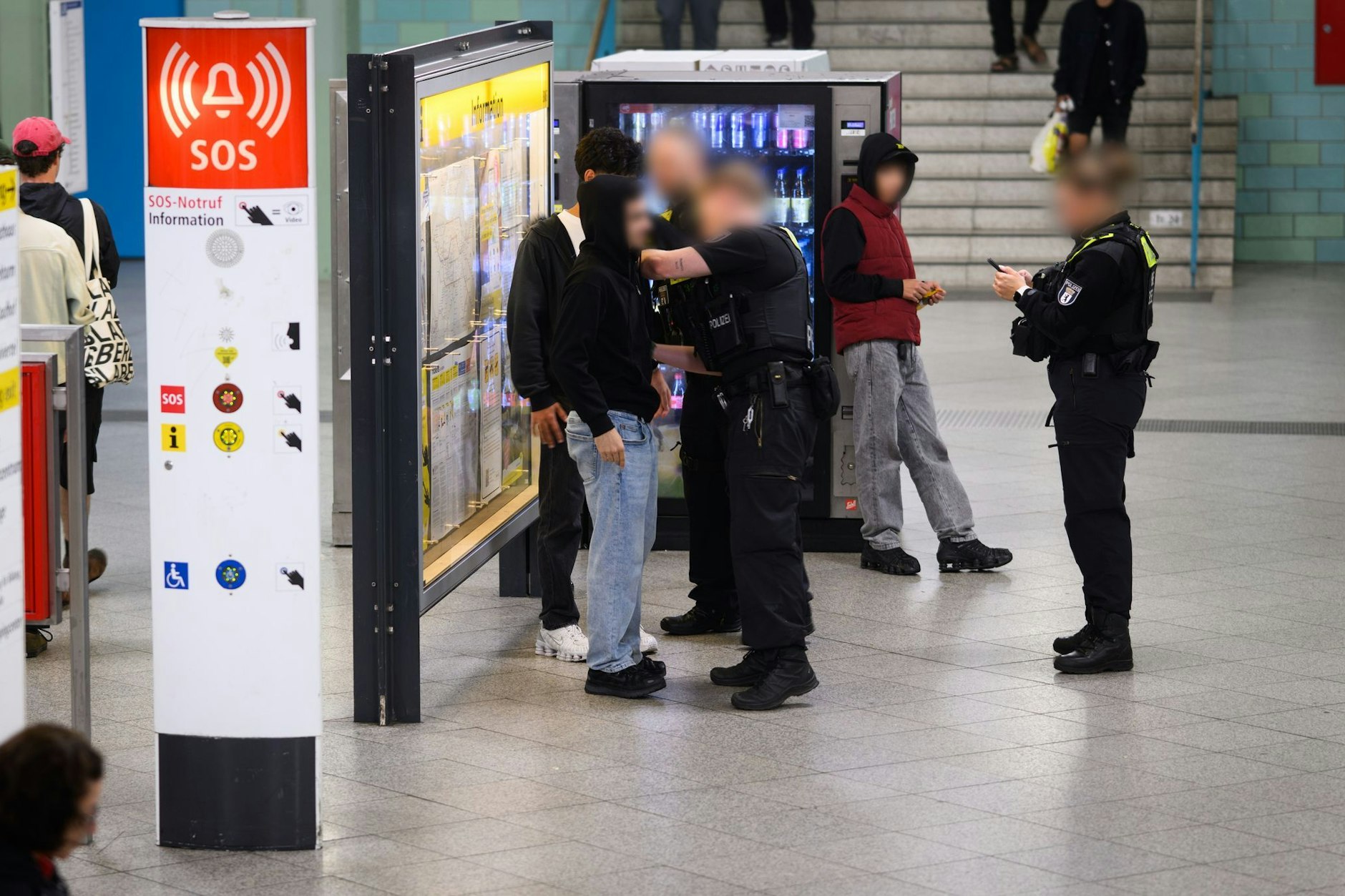 Polizeibeamte kontrollieren im U-Bahnhof Alexanderplatz Jugendliche.